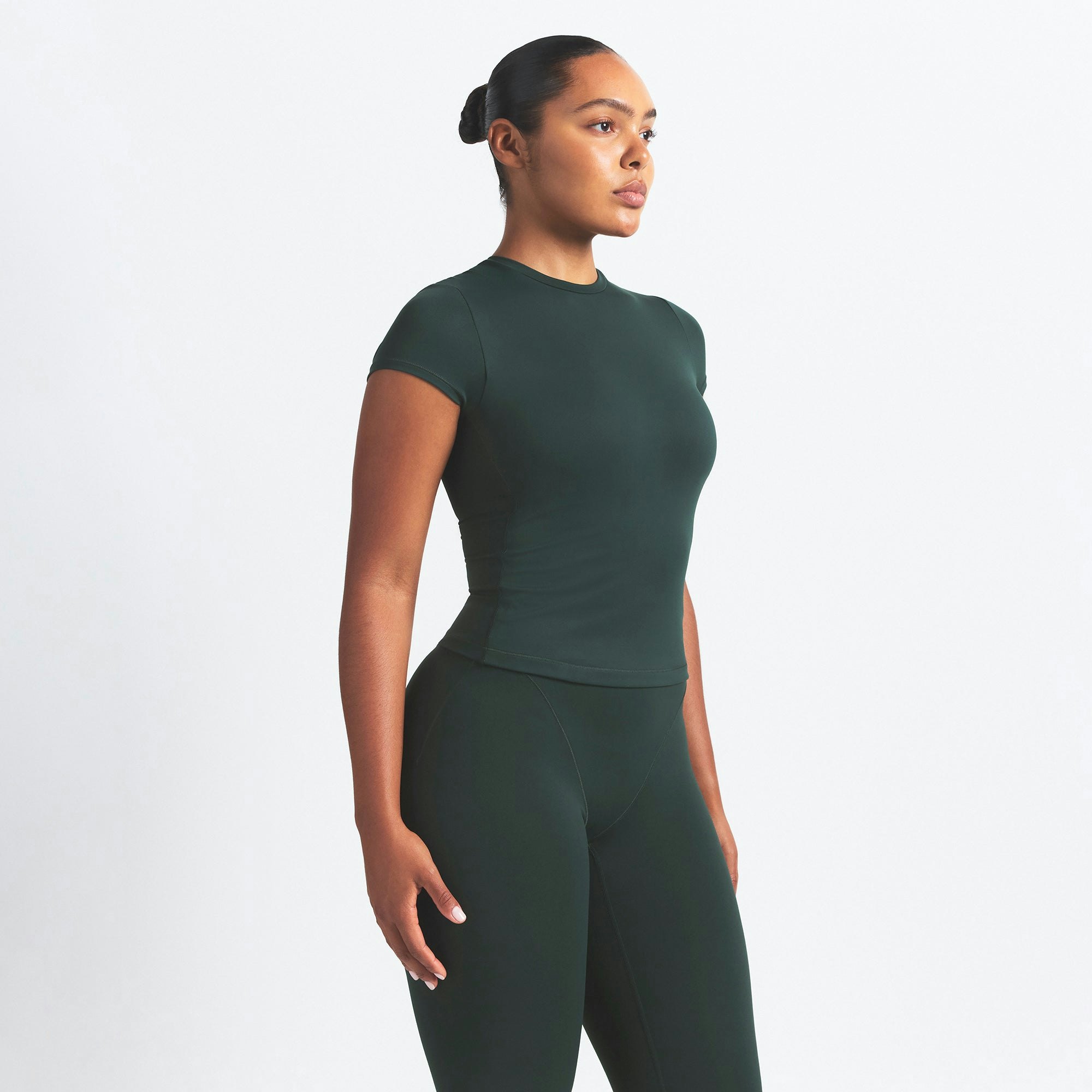 NikeSKIMS MATTE PADDED BABY TEE | DARK TEAL ON A MODEL SIDE VIEW @ | FOCUS: 0.0, 1.0, 0.9