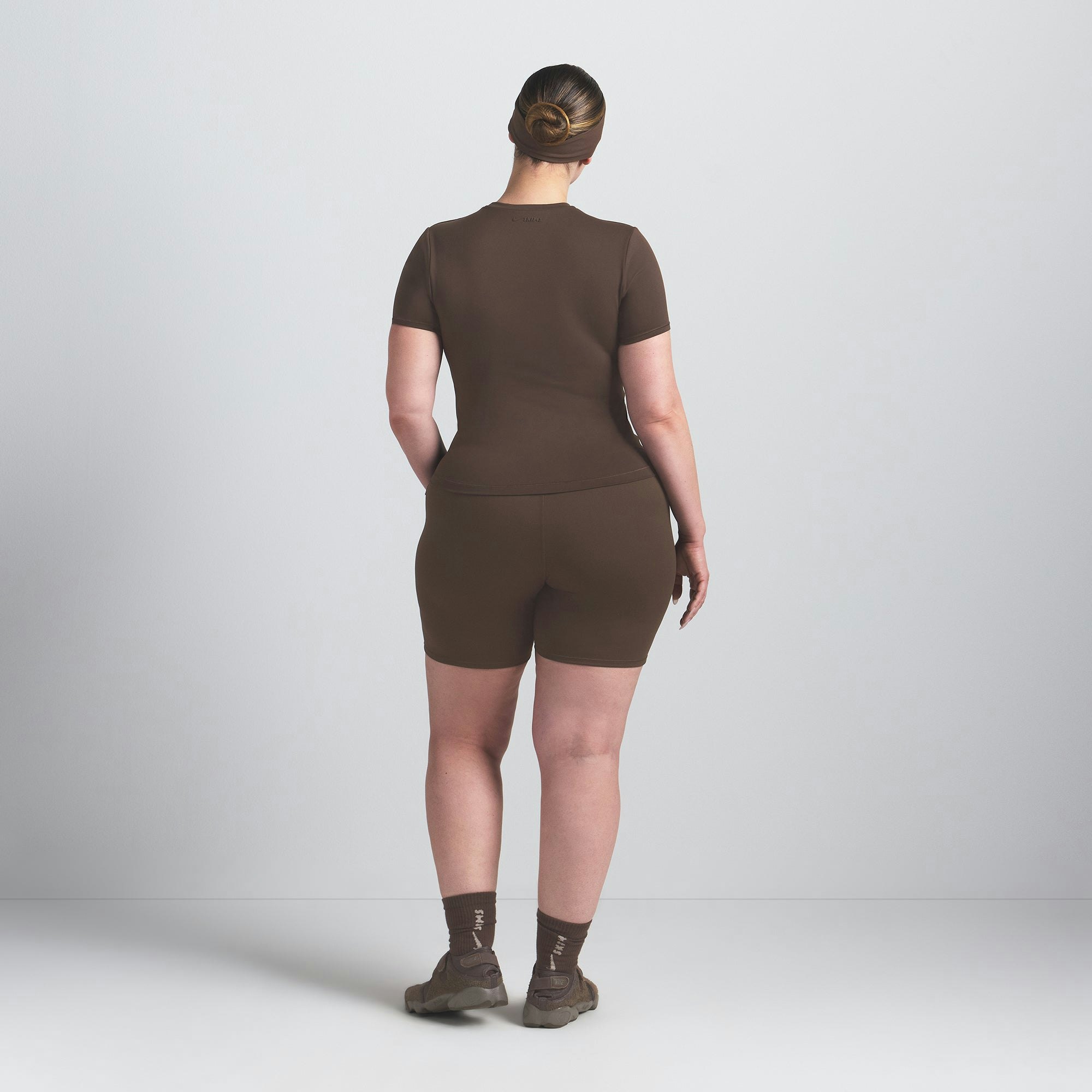 NikeSKIMS MATTE PADDED BABY TEE | DARK SEPIA ON A MODEL BACK VIEW @ | FOCUS: 0.0, 1.0, 0.9