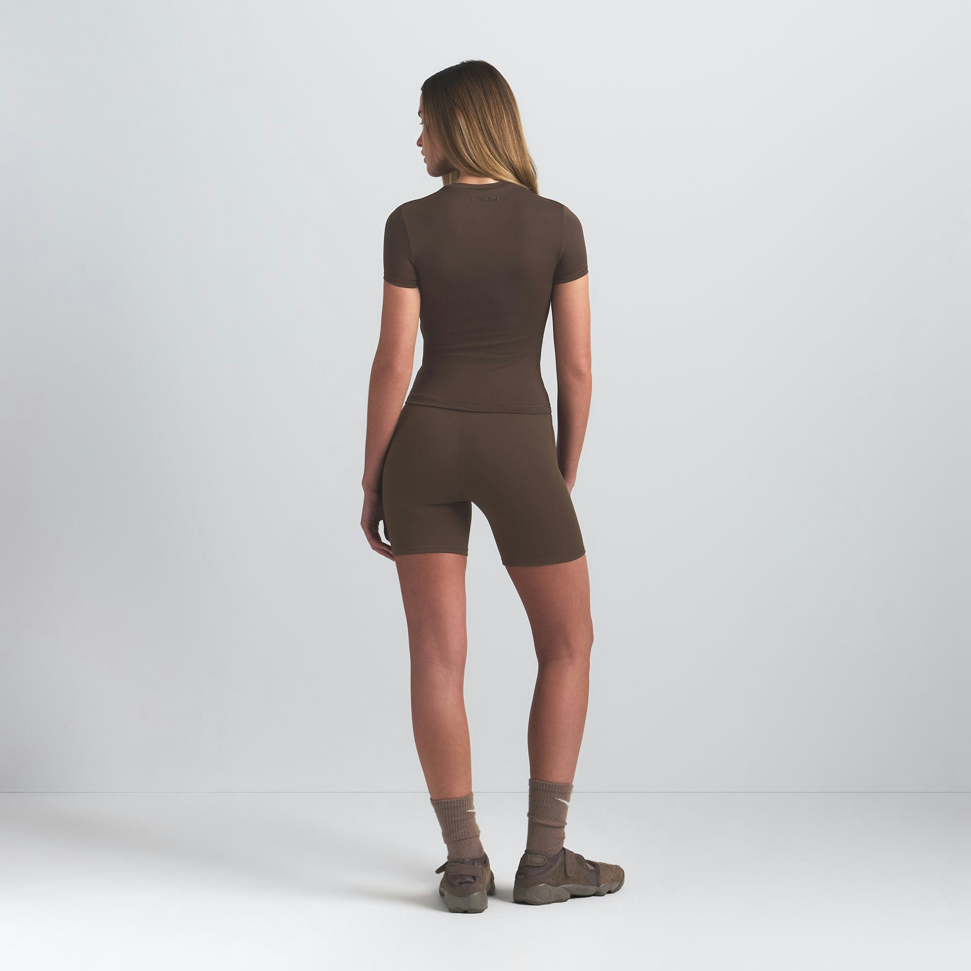 NikeSKIMS MATTE PADDED BABY TEE | DARK SEPIA ON A MODEL BACK VIEW @ | FOCUS: 0.0, 1.0, 0.9