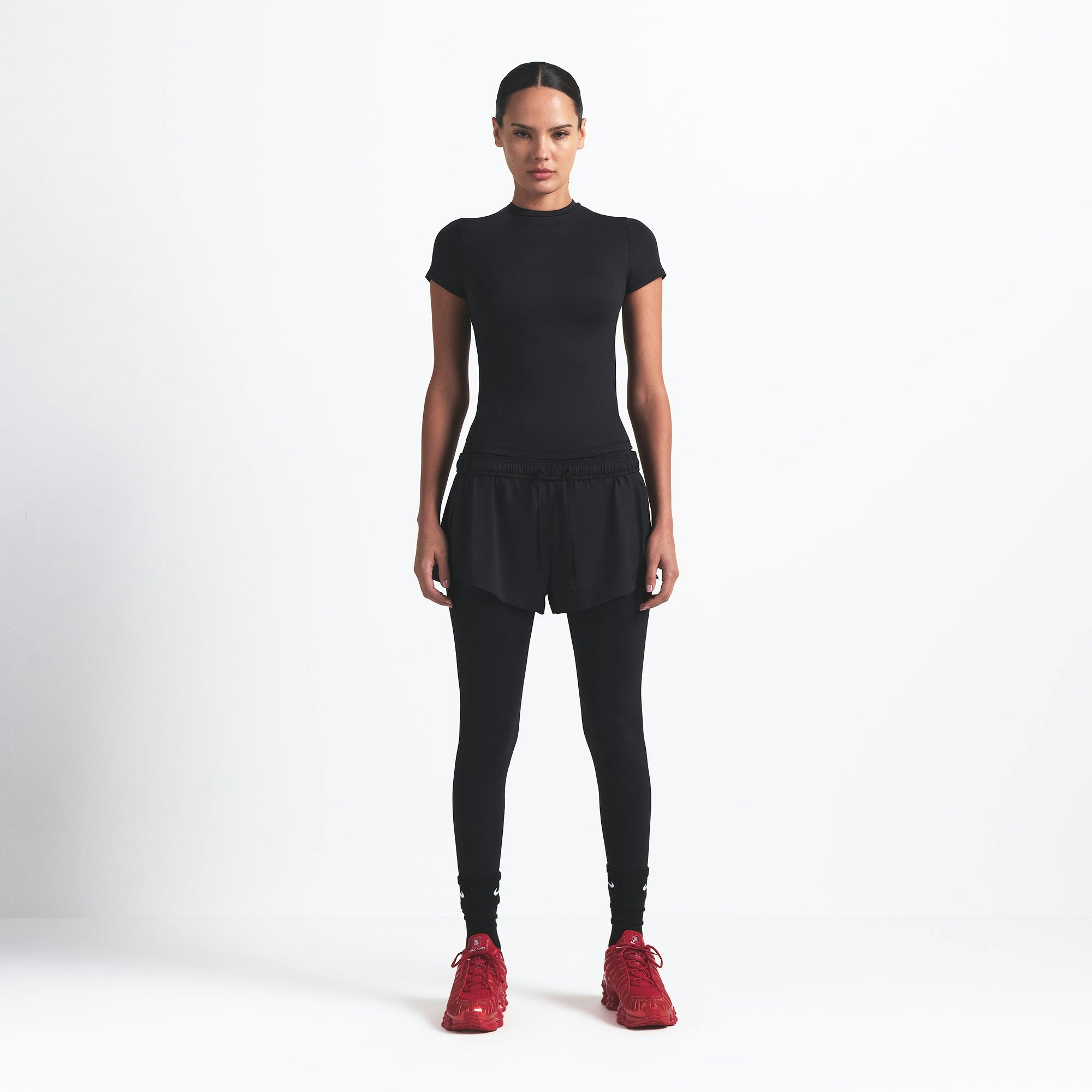 NikeSKIMS MATTE PADDED BABY TEE | OBSIDIAN ON A MODEL FRONT VIEW @ | FOCUS: 0.9, 0.1, 0.7