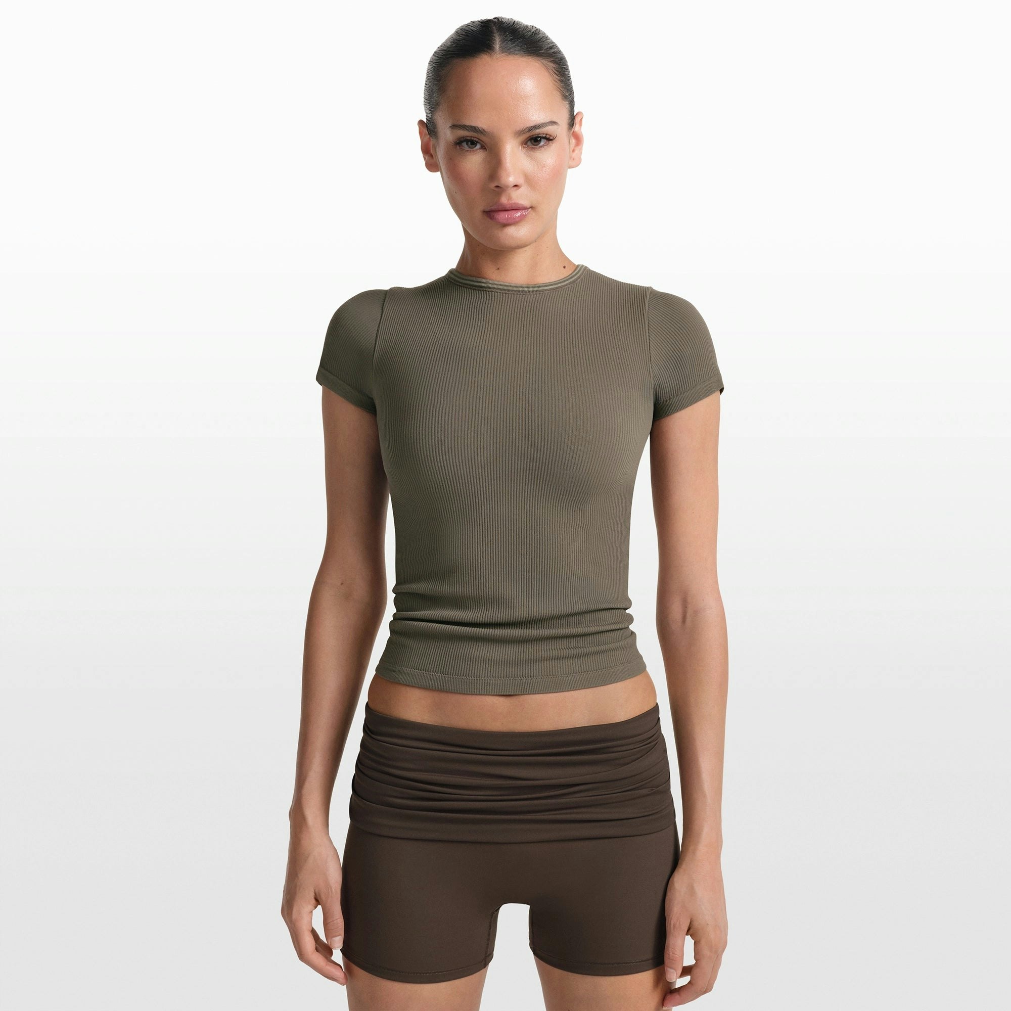 NikeSKIMS RIBBED SEAMLESS BABY TEE | DUSTY OAKMOSS ON A MODEL FRONT VIEW @ | FOCUS: 0.0, 1.0, 0.9