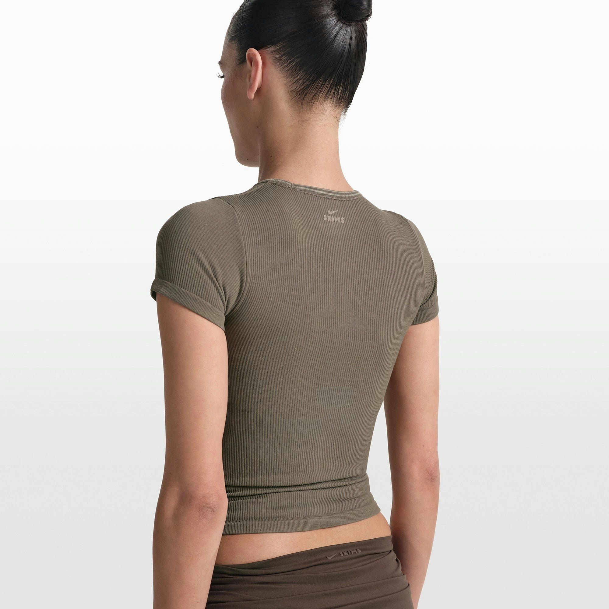 NikeSKIMS RIBBED SEAMLESS BABY TEE | DUSTY OAKMOSS/DUNE ON A MODEL FRONT VIEW @ | FOCUS: 0.0, 1.0, 0.9