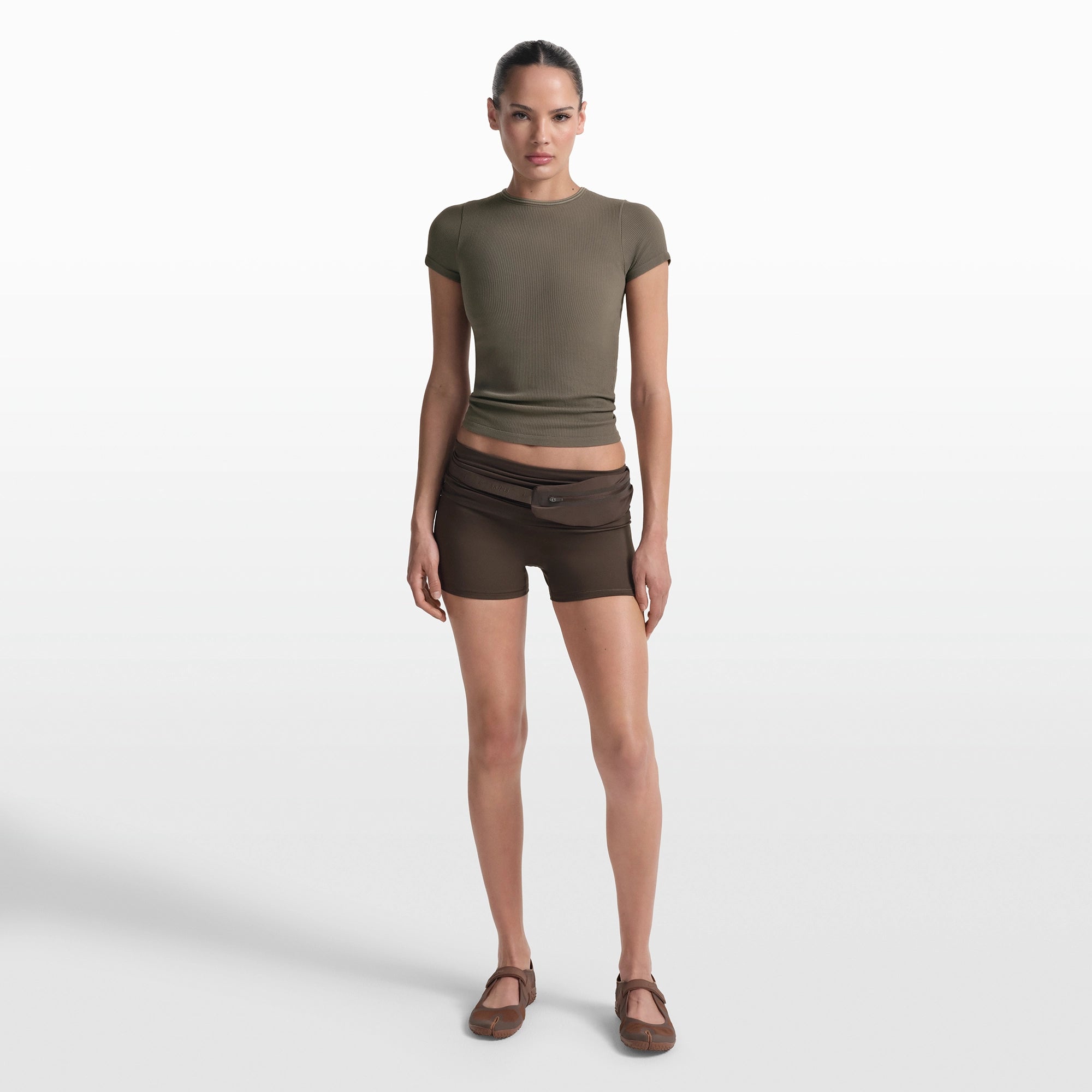 NikeSKIMS RIBBED SEAMLESS BABY TEE | DUSTY OAKMOSS/DUNE ON A MODEL FRONT VIEW @ | FOCUS: 0.0, 1.0, 0.9