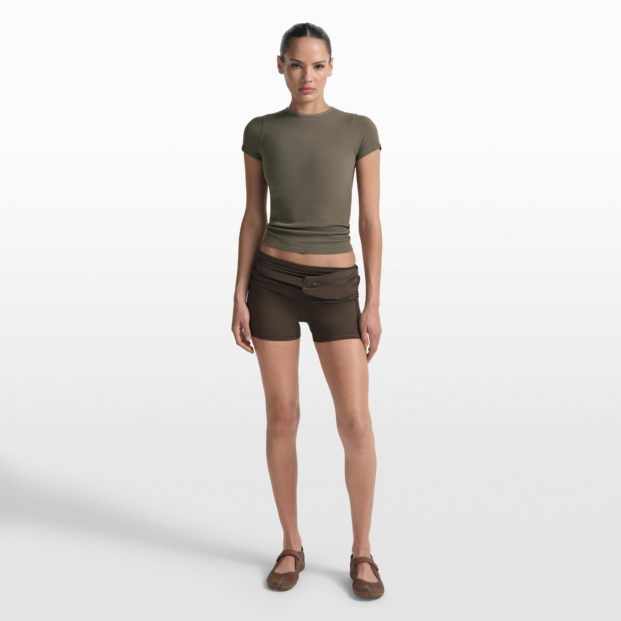 NikeSKIMS RIBBED SEAMLESS BABY TEE | DUSTY OAKMOSS/DUNE ON A MODEL FRONT VIEW @ | FOCUS: 0.0, 1.0, 0.9