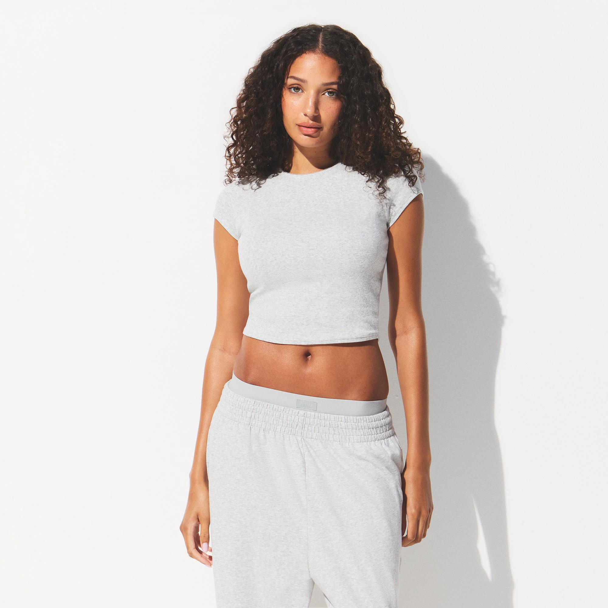 DROP NEEDLE POINTELLE BABY TEE | LIGHT HEATHER GREY ON A MODEL FRONT VIEW @ | FOCUS: 0.0, 1.0, 0.9