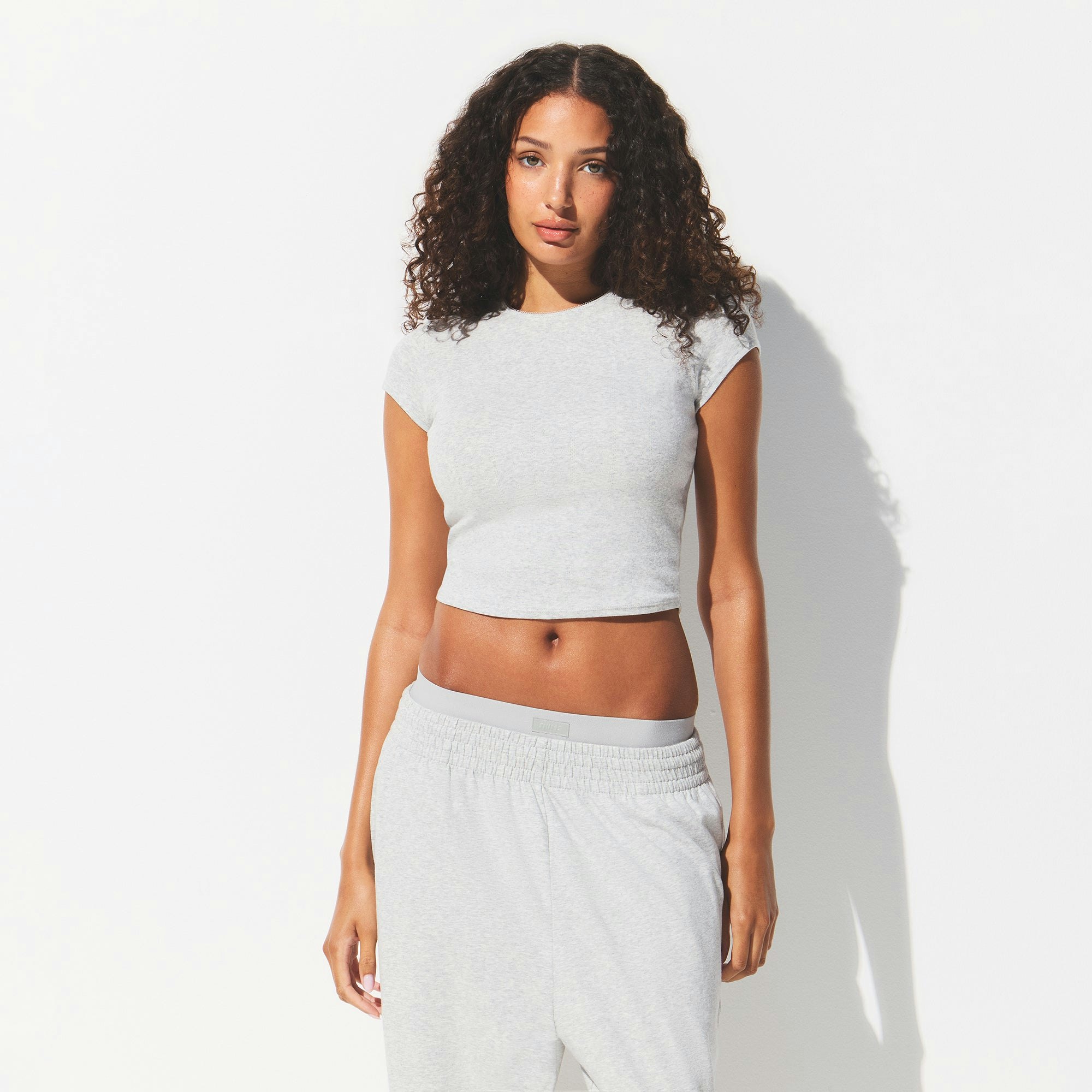 DROP NEEDLE POINTELLE BABY TEE | LIGHT HEATHER GREY ON A MODEL FRONT VIEW @ | FOCUS: 0.0, 1.0, 0.9