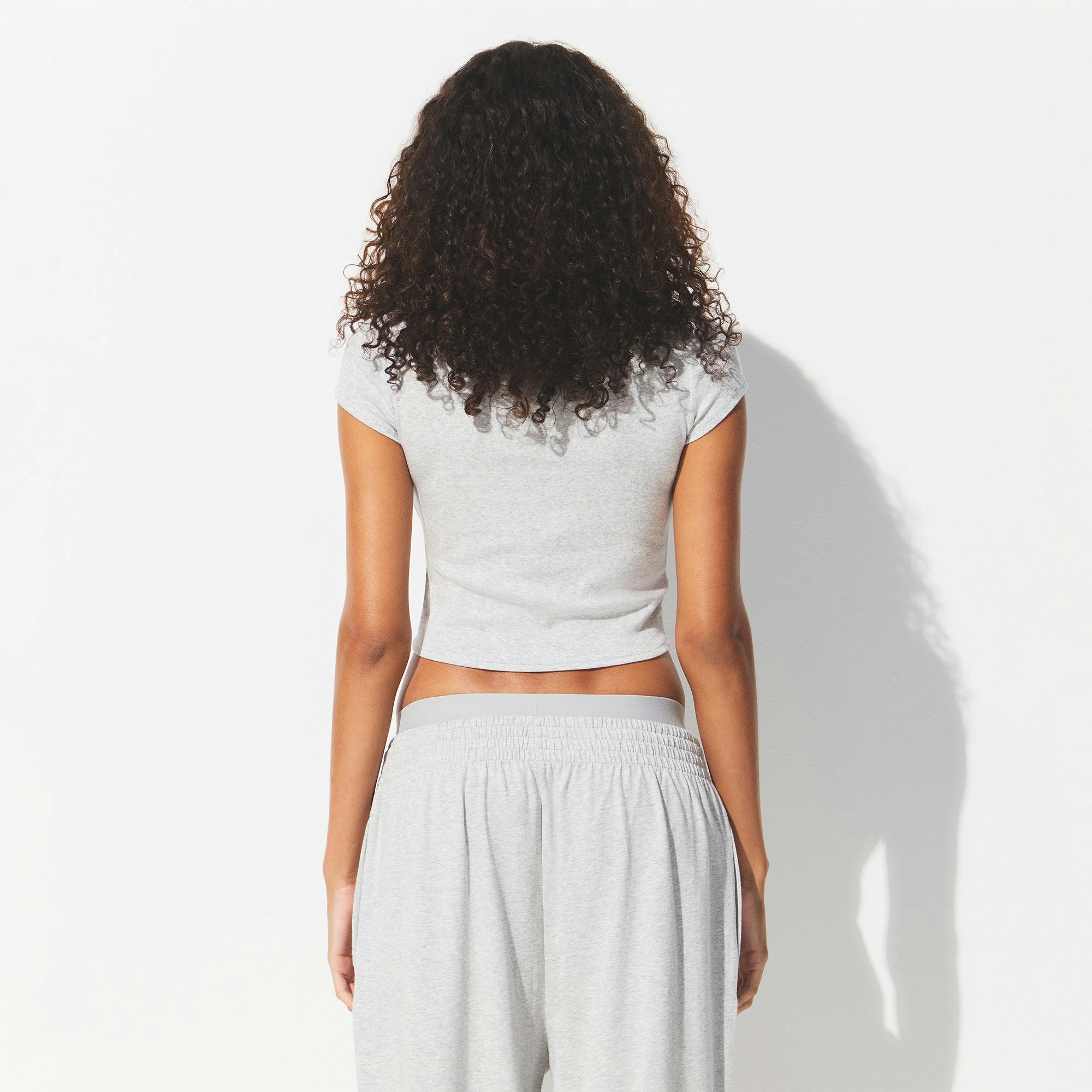 DROP NEEDLE POINTELLE BABY TEE | LIGHT HEATHER GREY ON A MODEL BACK VIEW @ | FOCUS: 0.0, 1.0, 0.9