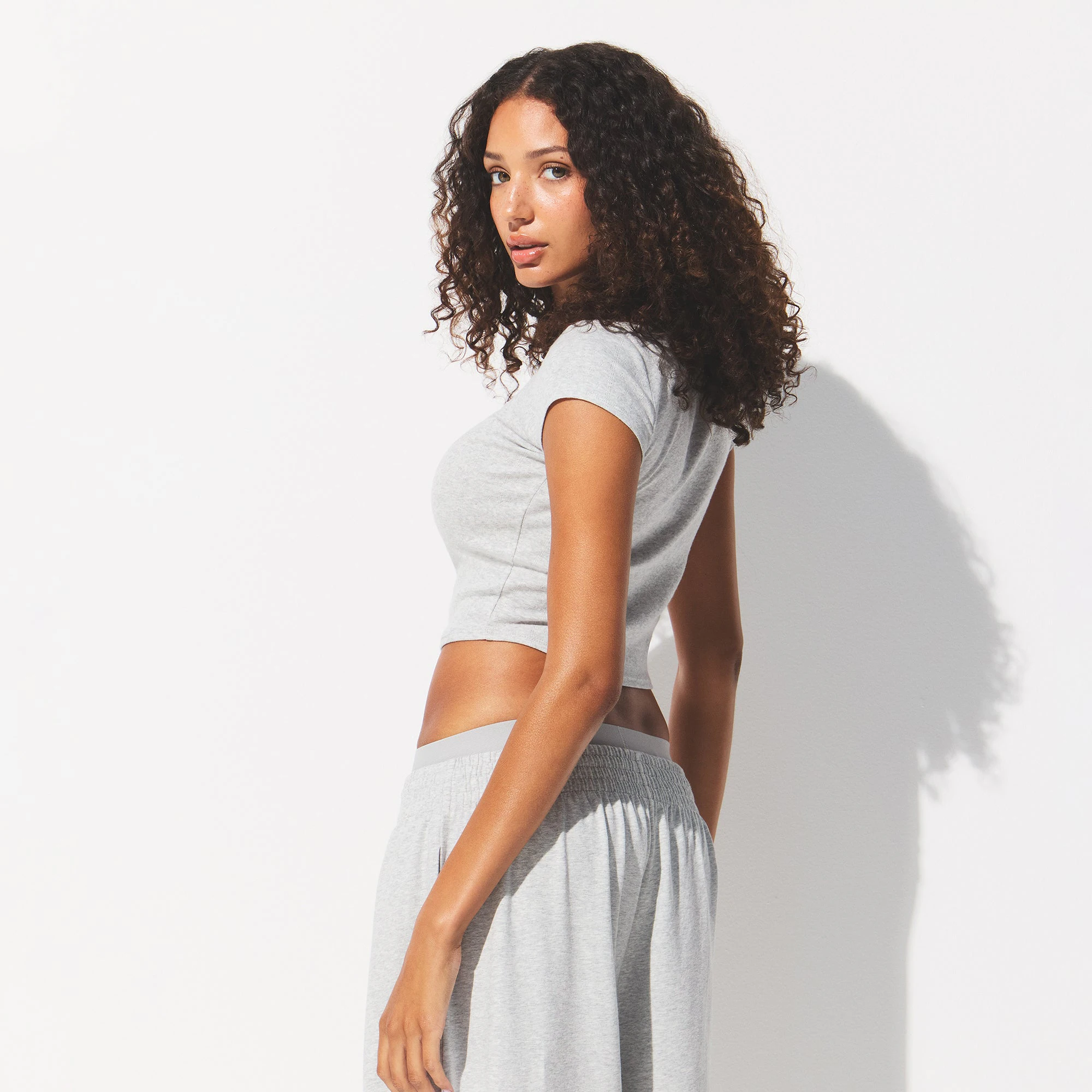 DROP NEEDLE POINTELLE BABY TEE | LIGHT HEATHER GREY ON A MODEL BACK VIEW @ | FOCUS: 0.0, 1.0, 0.9