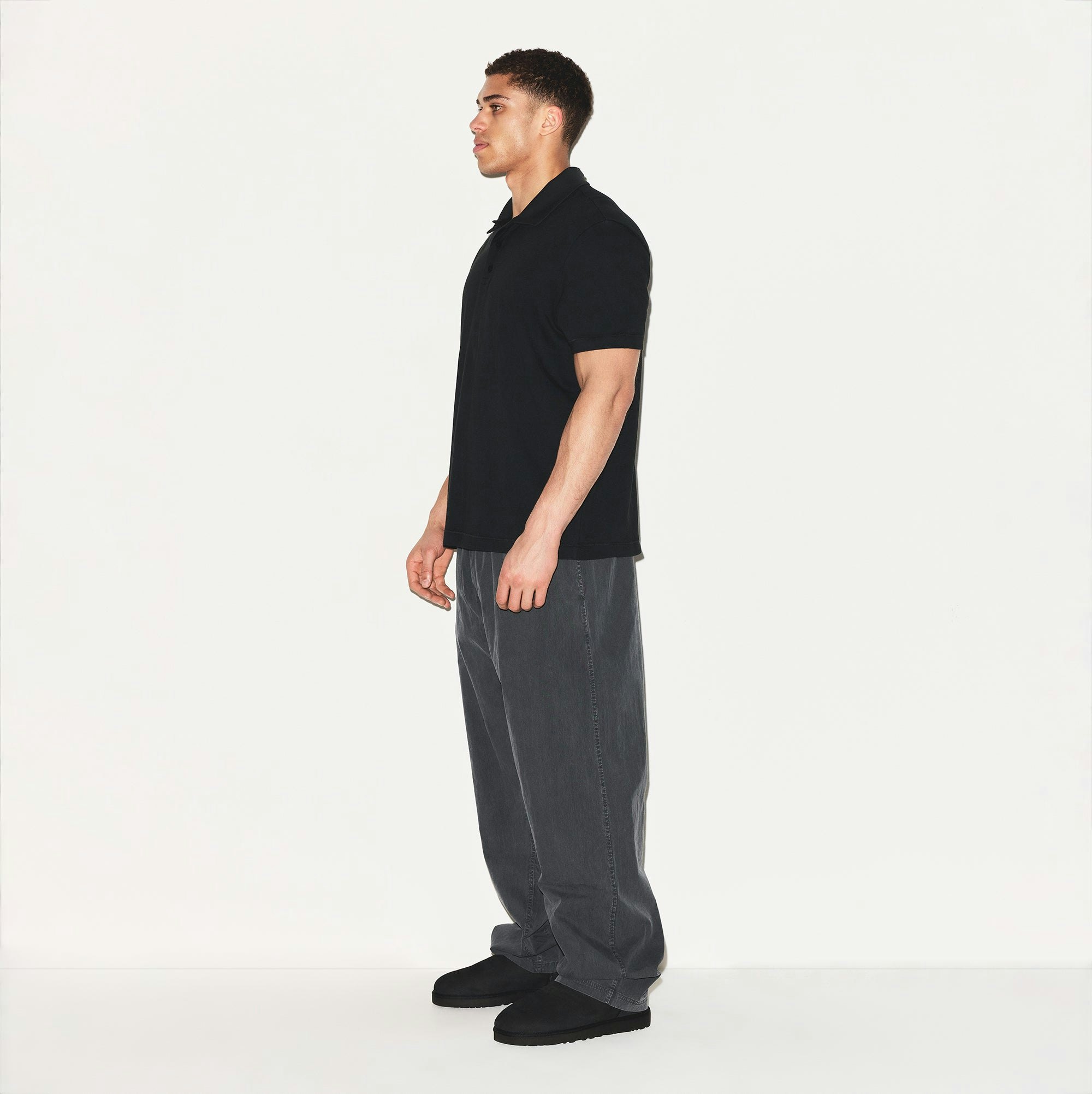 SKIMS COTTON MENS RELAXED POLO | ONYX ON A MODEL SIDE VIEW | FOCUS: 0.0, 1.0, 0.9