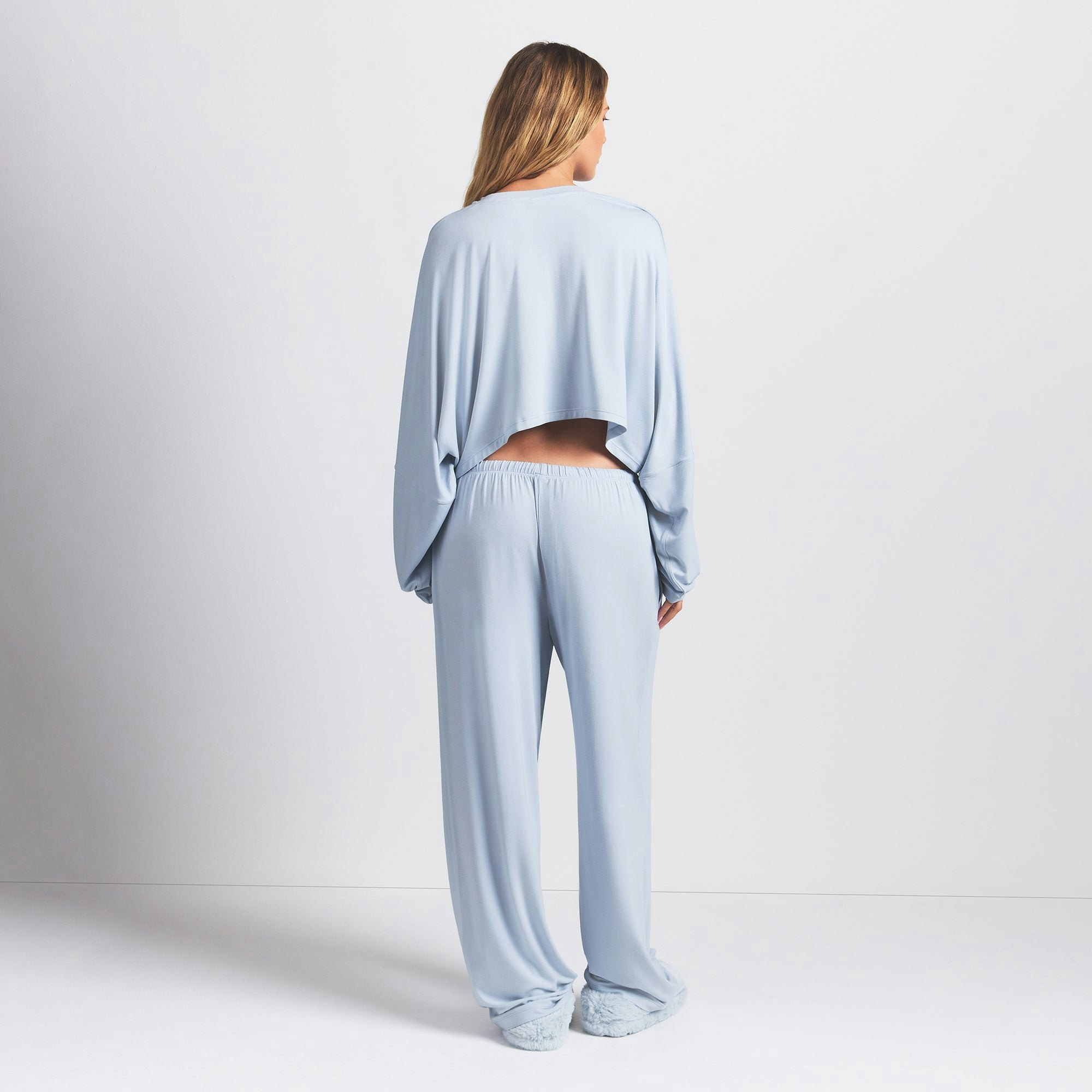 SKIMS SLEEP CROPPED LONG SLEEVE AND PANT SET | ZEN BLUE ON A MODEL BACK VIEW @ | FOCUS: 0.0, 1.0, 0.9