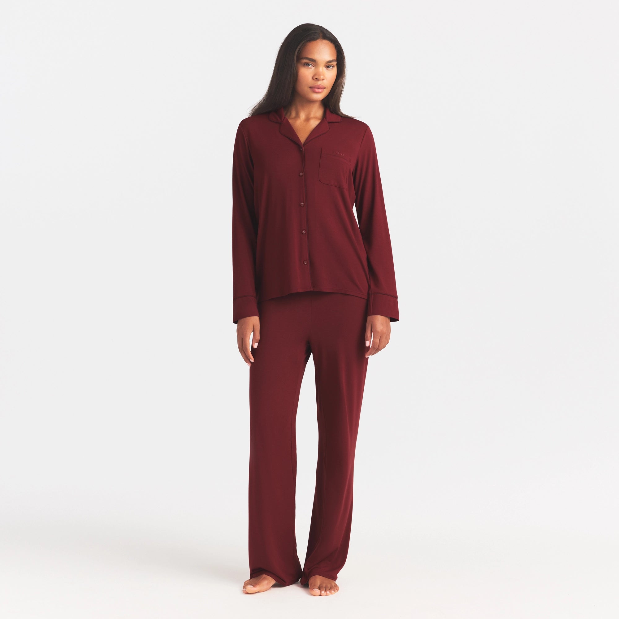 SKIMS SLEEP LONG SLEEVE BUTTON UP SET | MERLOT ON A MODEL FRONT VIEW @ | FOCUS: 0.0, 1.0, 0.9