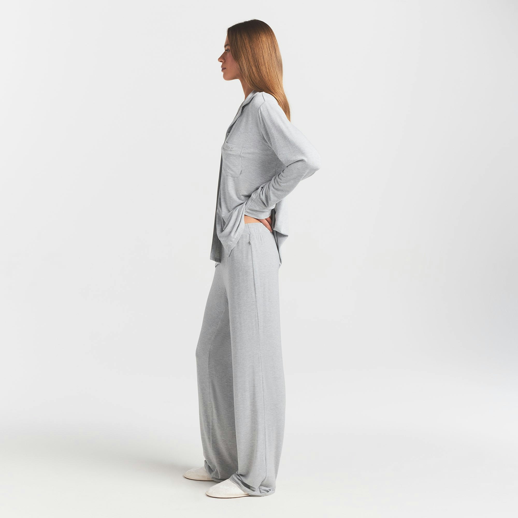 SKIMS SLEEP LONG SLEEVE BUTTON UP SET | LIGHT HEATHER GREY ON A MODEL SIDE VIEW @ | FOCUS: 0.0, 1.0, 0.9