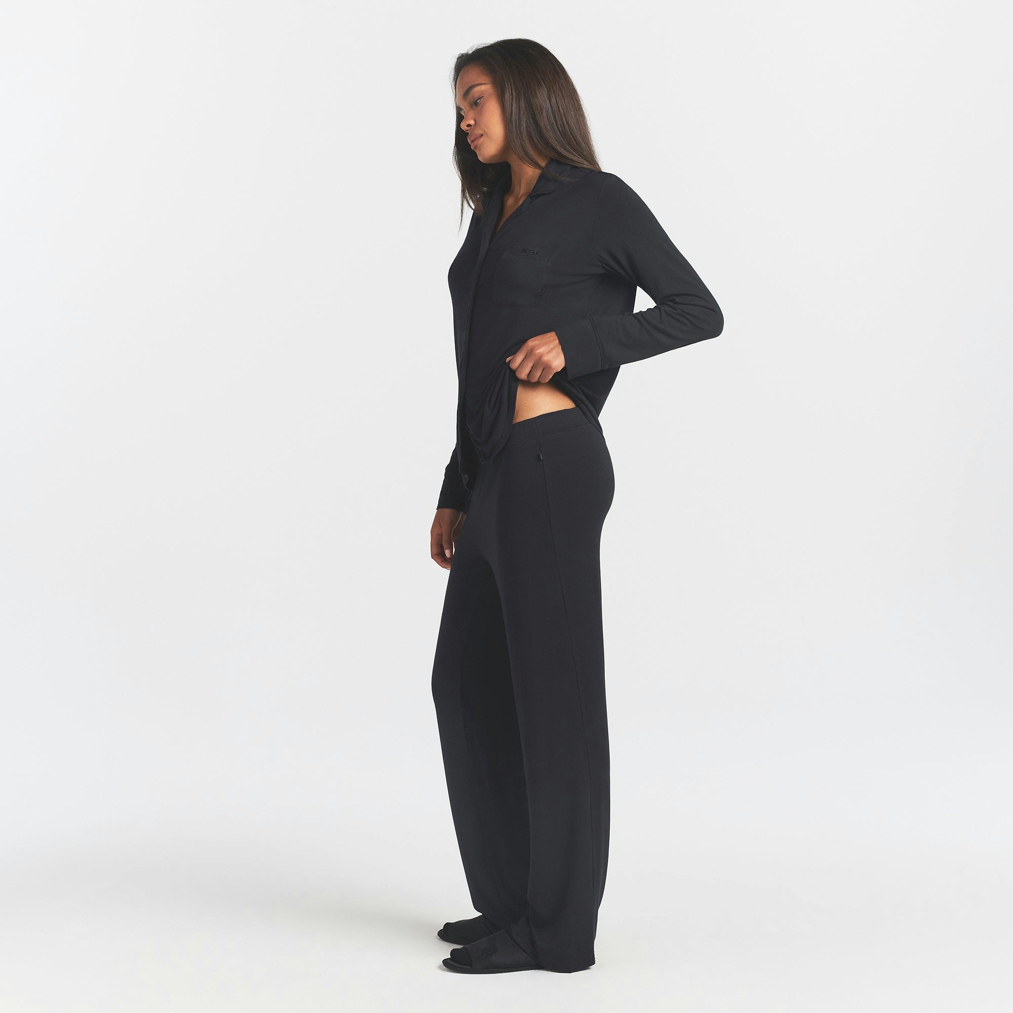SKIMS SLEEP LONG SLEEVE BUTTON UP SET | ONYX ON A MODEL SIDE VIEW @ | FOCUS: 0.0, 1.0, 0.9