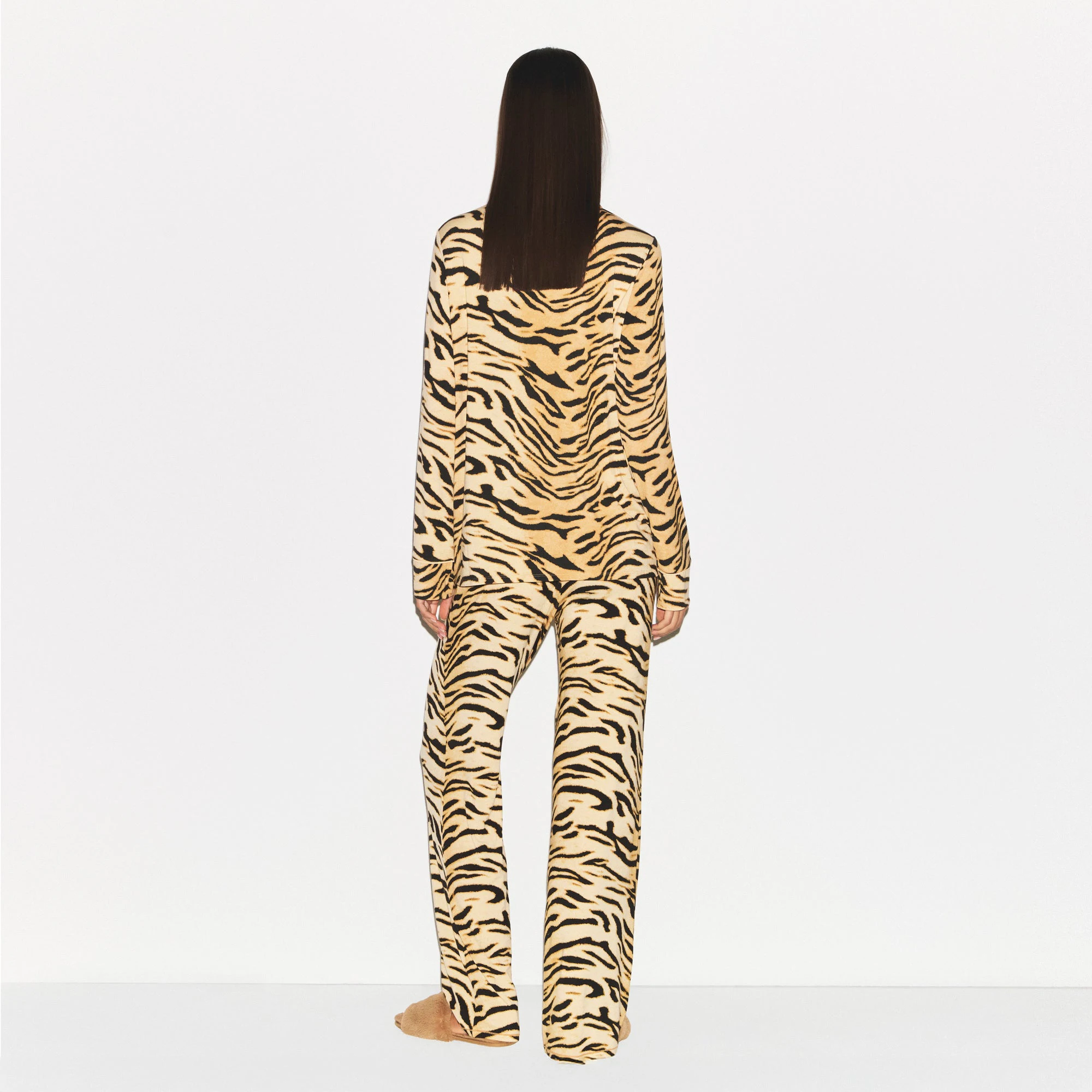 SKIMS SLEEP LONG SLEEVE BUTTON UP SET | BRONZE TIGER PRINT ON A MODEL SIDE VIEW @ | FOCUS: 0.0, 1.0, 0.9