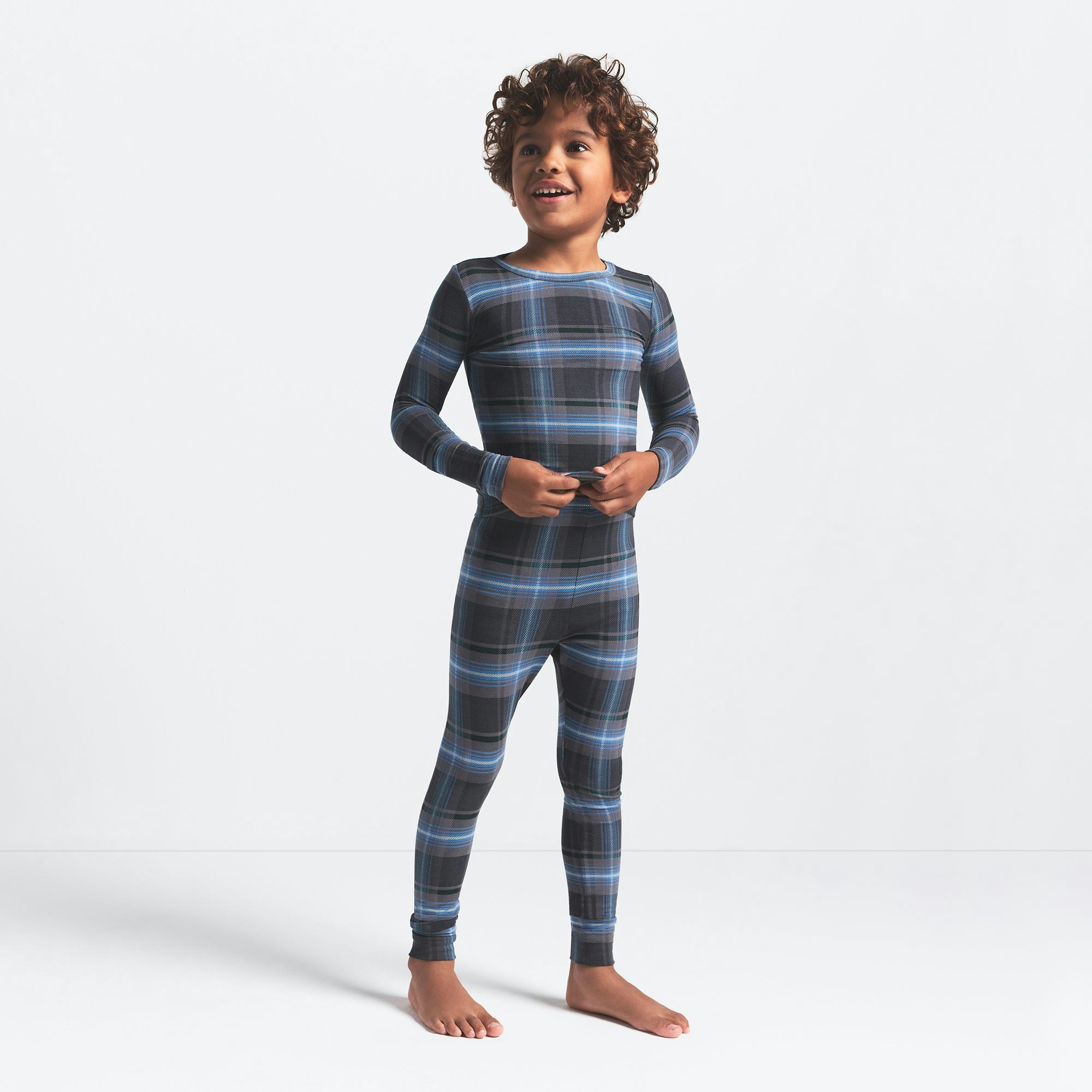 SKIMS SLEEP KIDS SLEEP SET | GLACIER PLAID ON A MODEL FRONT VIEW @ | FOCUS: 0.0, 1.0, 0.9