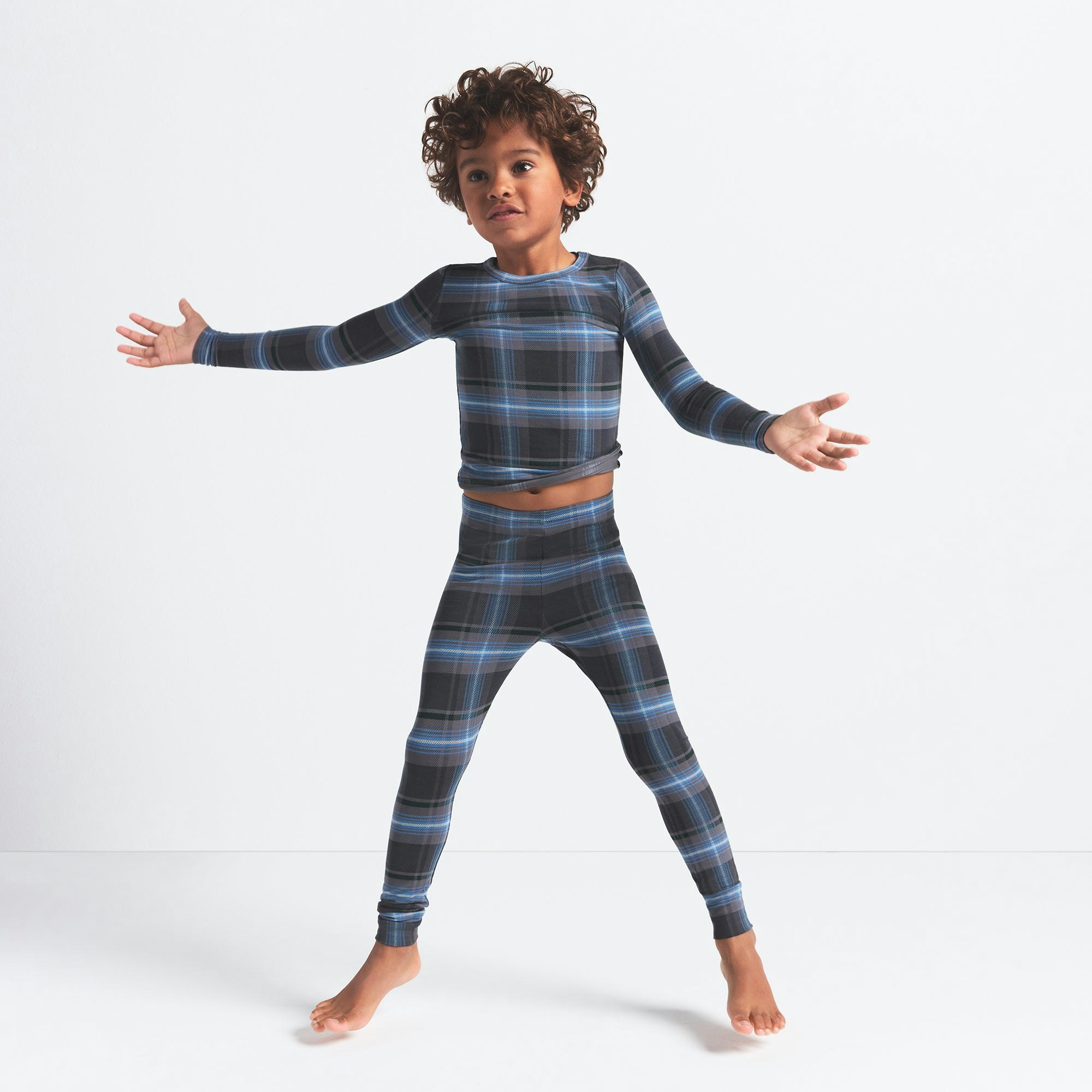 SKIMS SLEEP KIDS SLEEP SET | GLACIER PLAID ON A MODEL FRONT VIEW @ | FOCUS: 0.0, 1.0, 0.9