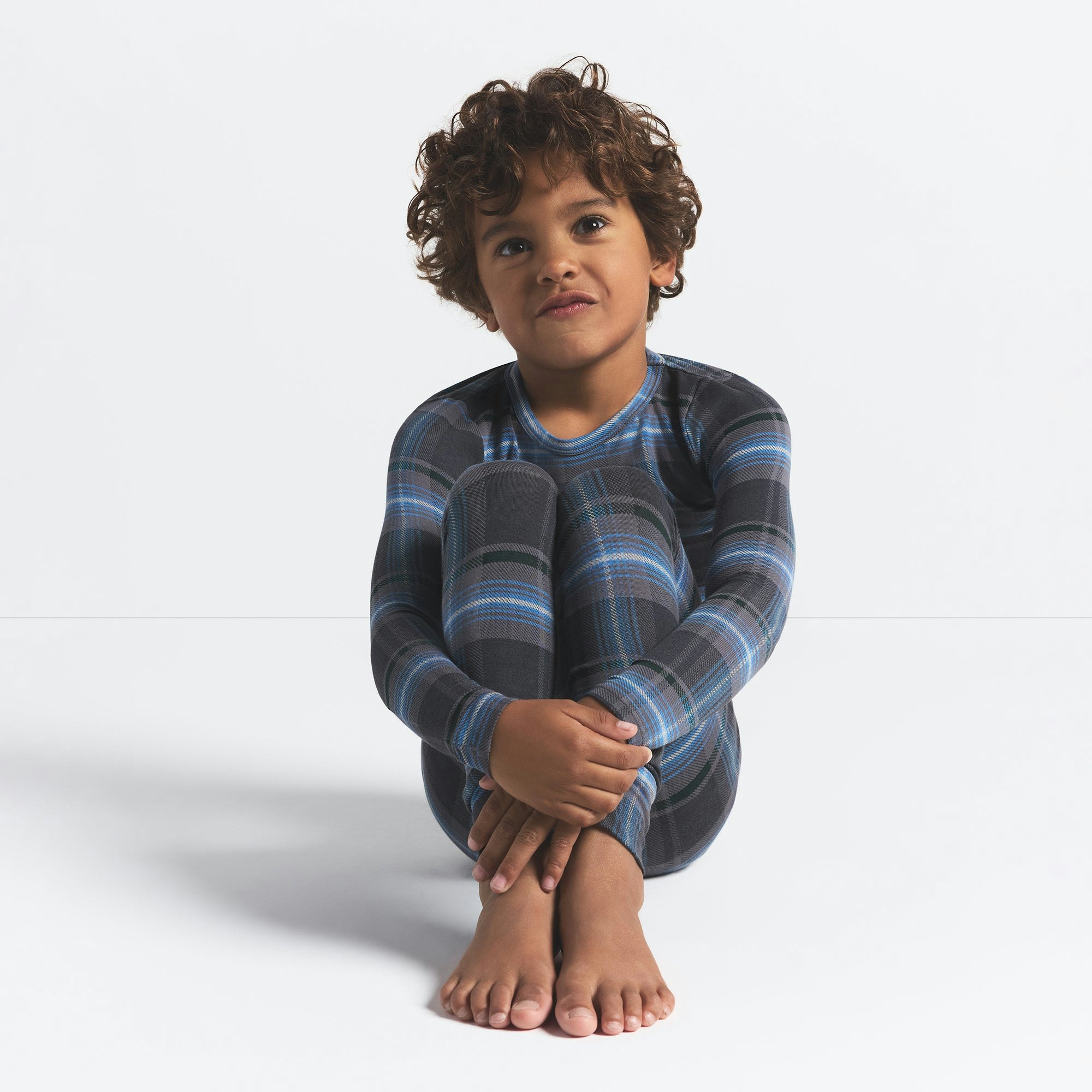 SKIMS SLEEP KIDS SLEEP SET | GLACIER PLAID ON A MODEL FRONT VIEW @ | FOCUS: 0.0, 1.0, 0.9