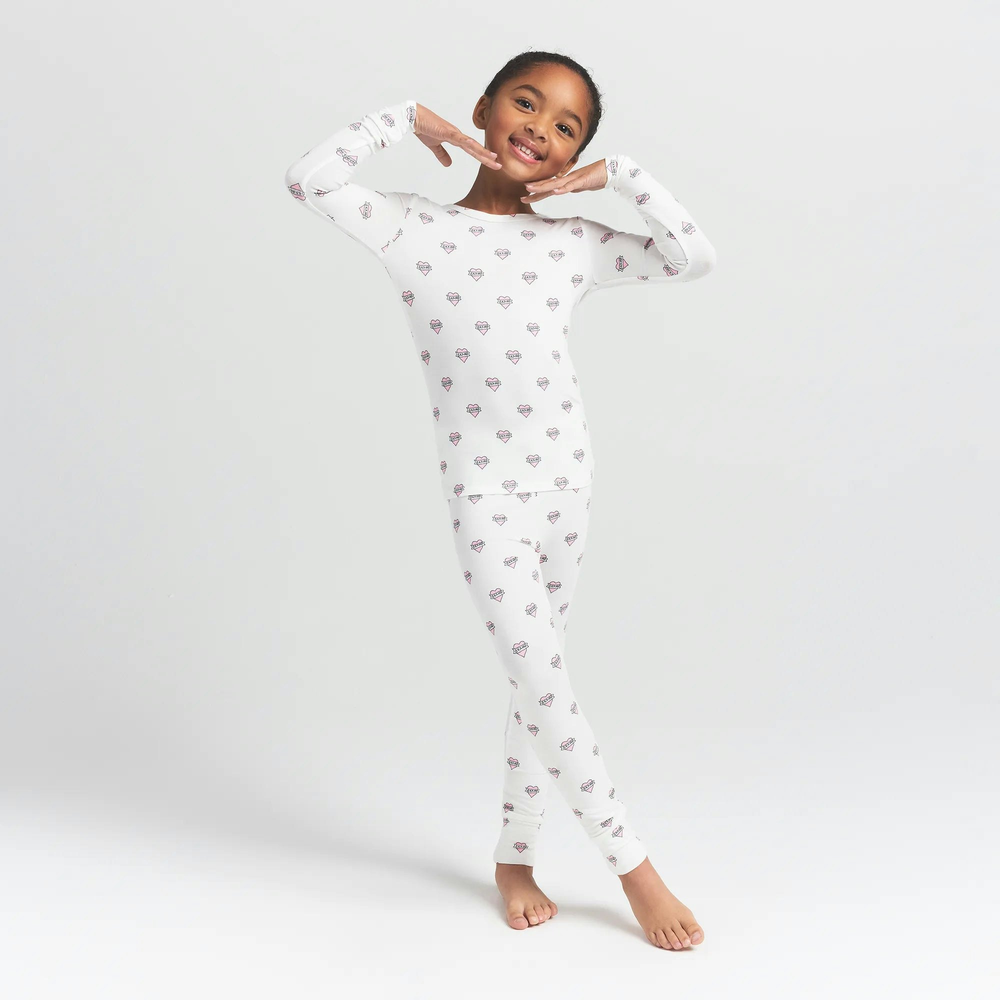 SKIMS SLEEP KIDS SLEEP SET | MARBLE HEART BANNER ON A MODEL FRONT VIEW @ | FOCUS: 0.0, 1.0, 0.9