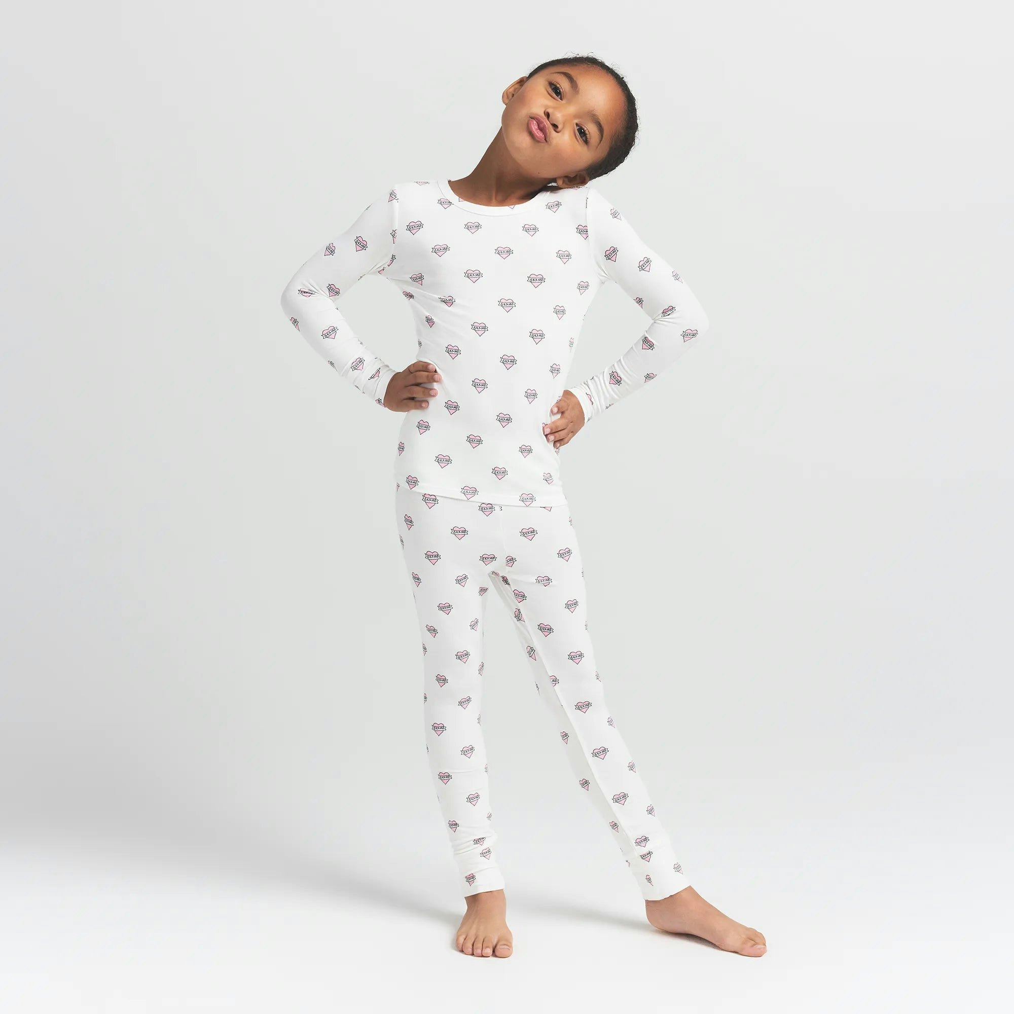 SKIMS SLEEP KIDS SLEEP SET | MARBLE HEART BANNER ON A MODEL FRONT VIEW @ | FOCUS: 0.0, 1.0, 0.9