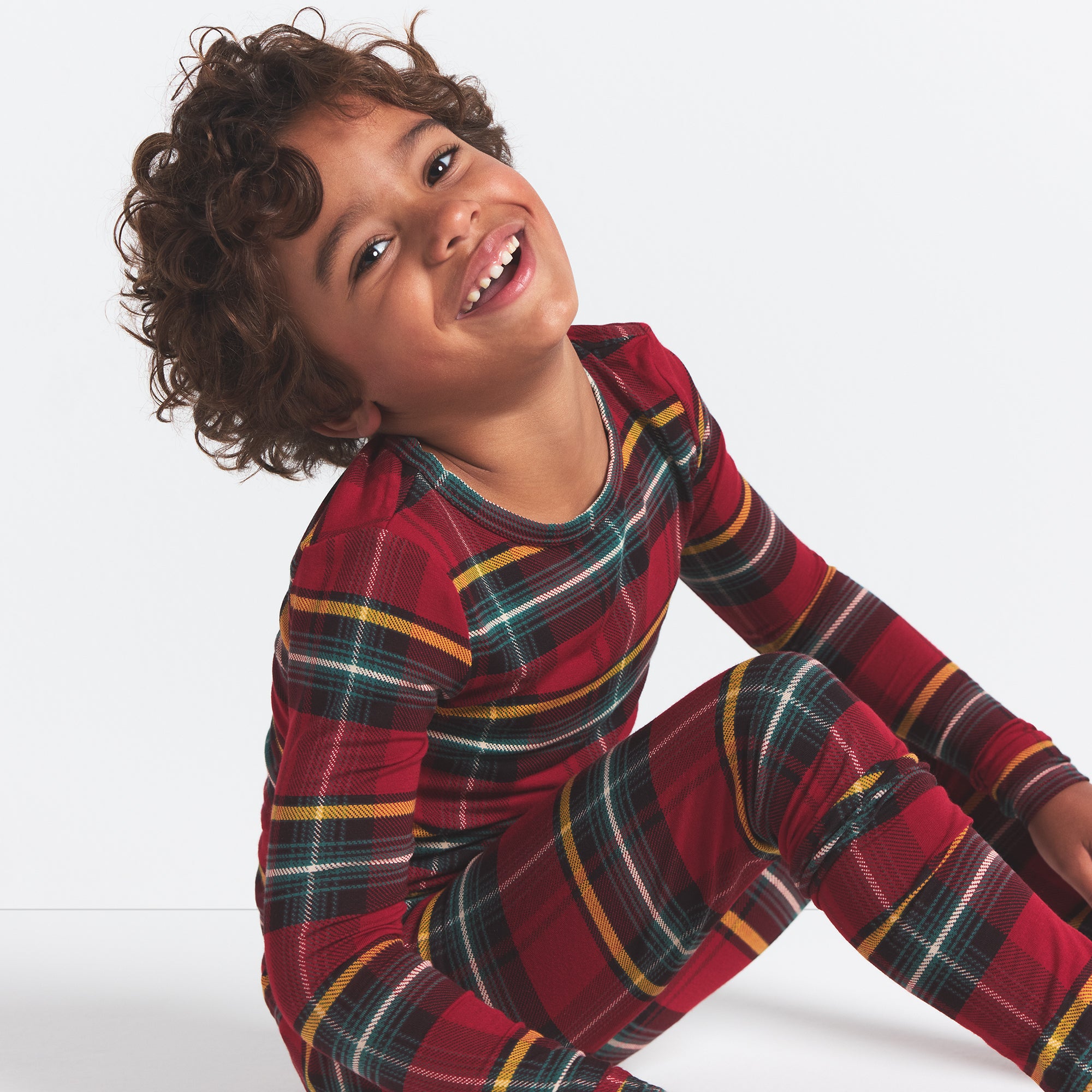 SKIMS SLEEP KIDS SLEEP SET | RED HOLIDAY PLAID ON A MODEL SIDE VIEW @ | FOCUS: 0.0, 1.0, 0.9