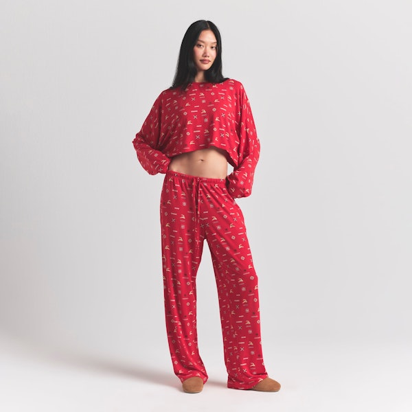 SKIMS SLEEP CROPPED LONG SLEEVE AND PANT SET | CRANBERRY VINTAGE DEER PRINT ON A MODEL FRONT VIEW @ | FOCUS: 0.0, 1.0, 0.9
