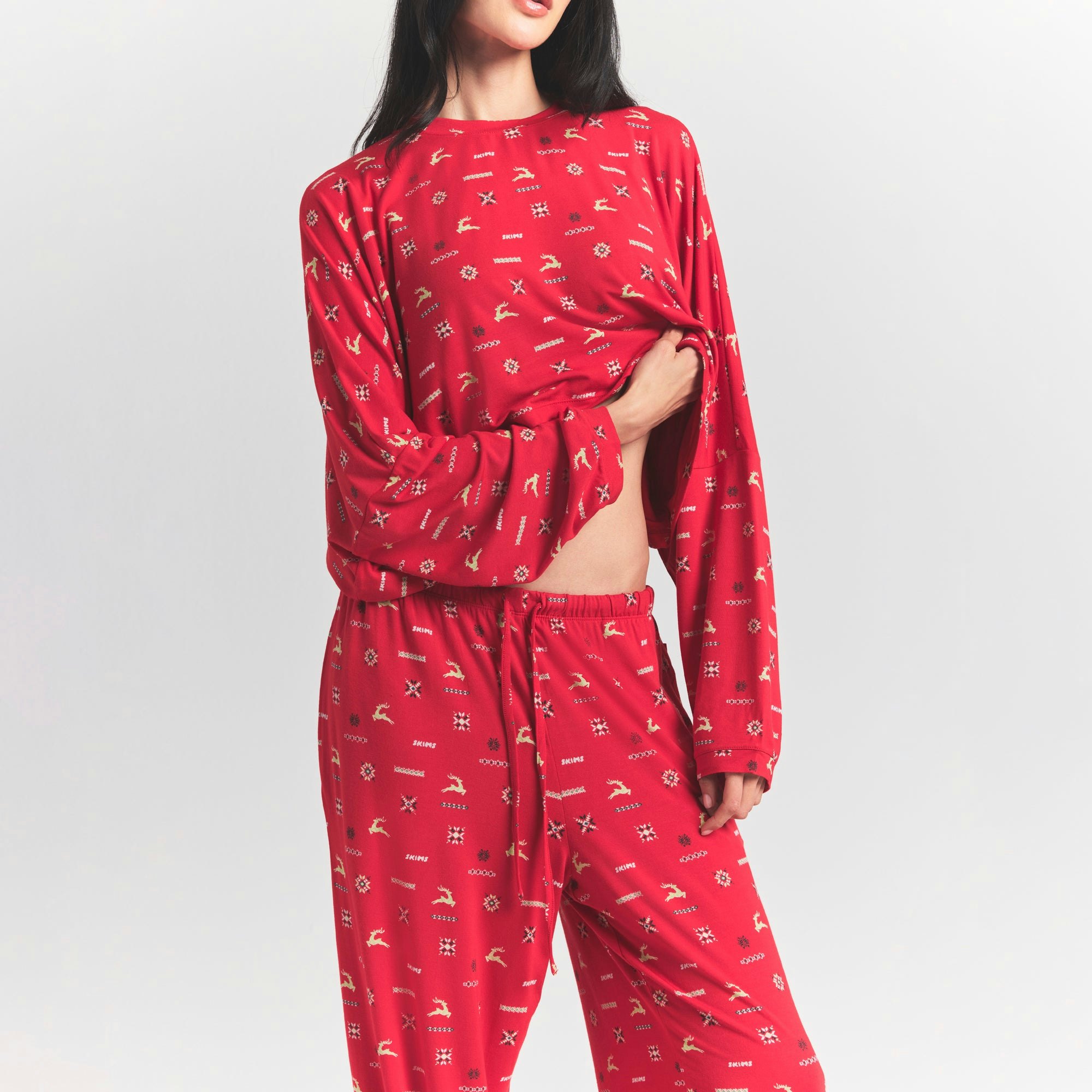 SKIMS SLEEP CROPPED LONG SLEEVE AND PANT SET | CRANBERRY VINTAGE DEER PRINT ON A MODEL FRONT VIEW @ | FOCUS: 0.0, 1.0, 0.9