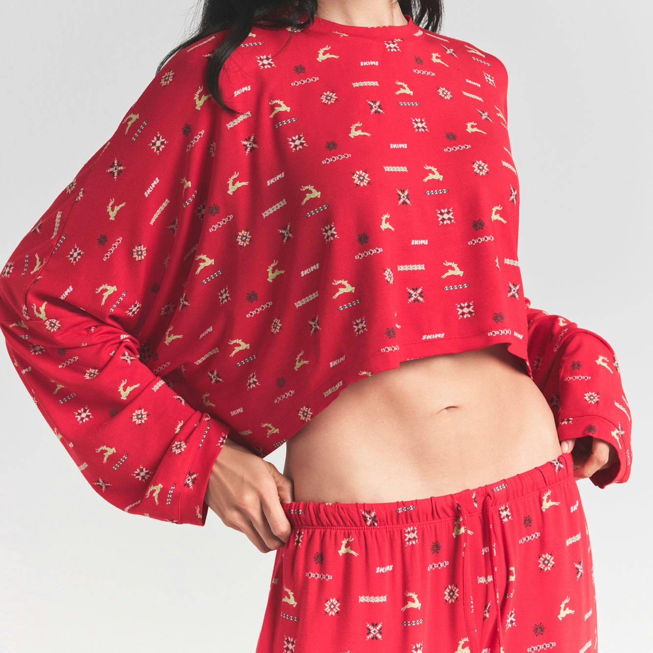 SKIMS SLEEP CROPPED LONG SLEEVE AND PANT SET | CRANBERRY VINTAGE DEER PRINT ON A MODEL FRONT VIEW @ | FOCUS: 0.0, 1.0, 0.9