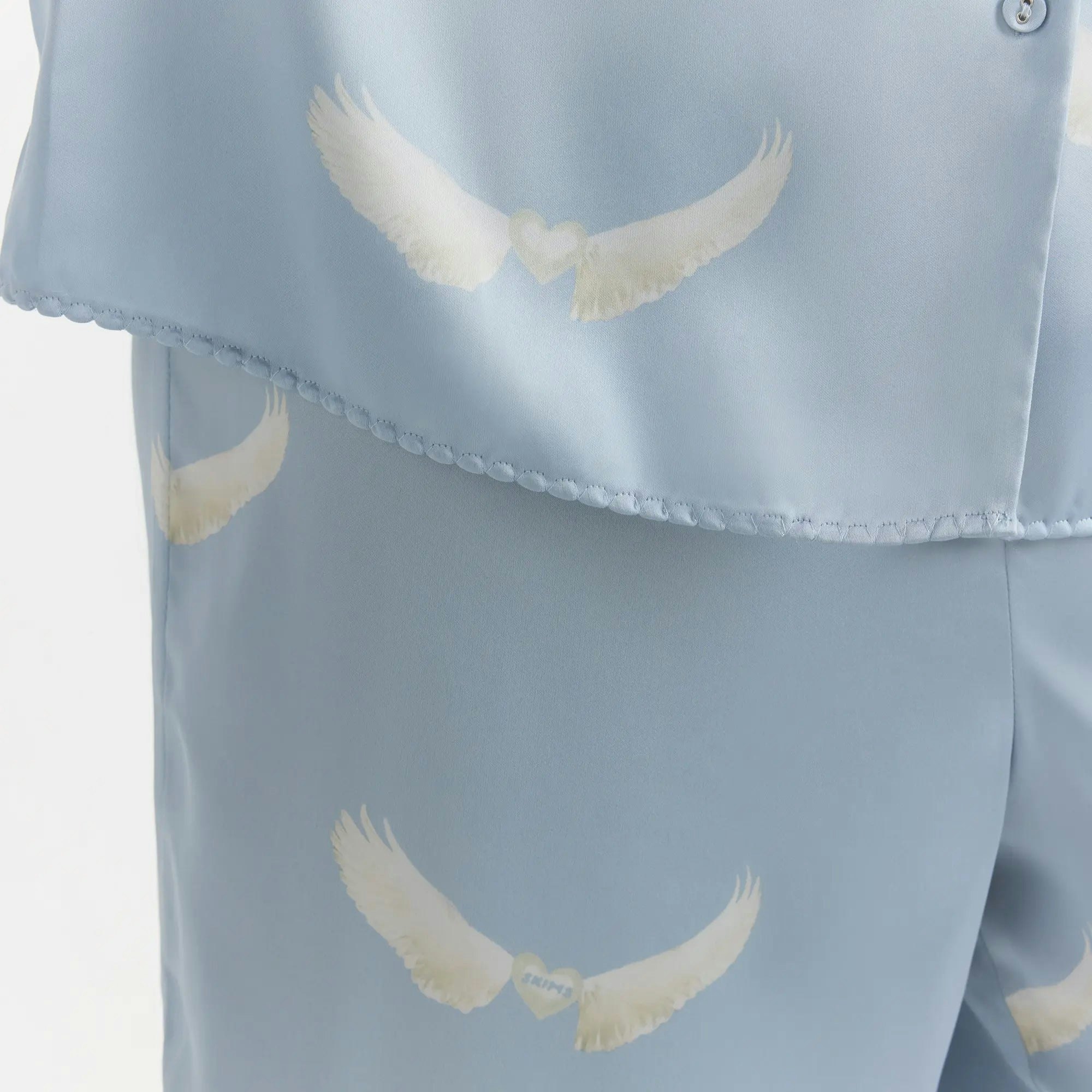 WOVEN SHINE LONG SLEEP SET | AERO WING HEARTS PRINT ON A MODEL SIDE VIEW @ | FOCUS: 0.0, 1.0, 0.9