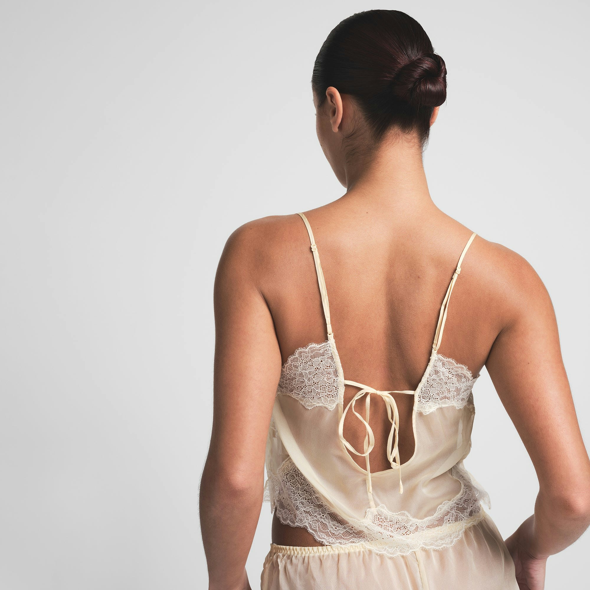 SKIMS ROMANCE LACE CAMI AND SHORT SET | BUTTER ON A MODEL BACK VIEW