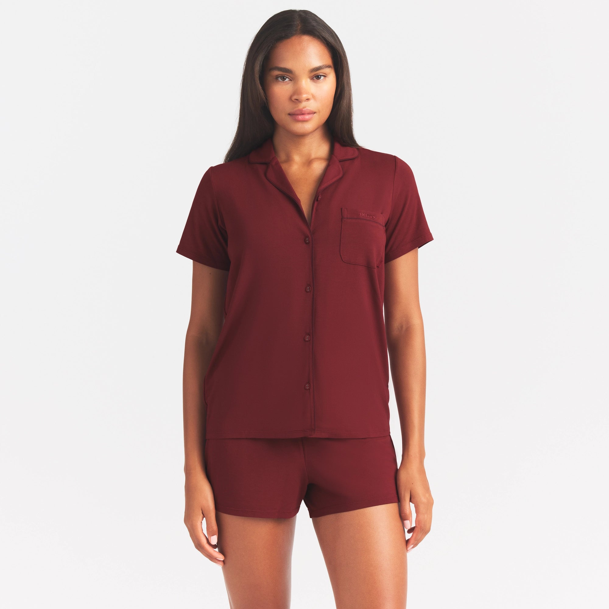 SKIMS SLEEP SHORT SLEEVE BUTTON UP SET | MERLOT ON A MODEL SIDE VIEW @ | FOCUS: 0.0, 1.0, 0.9