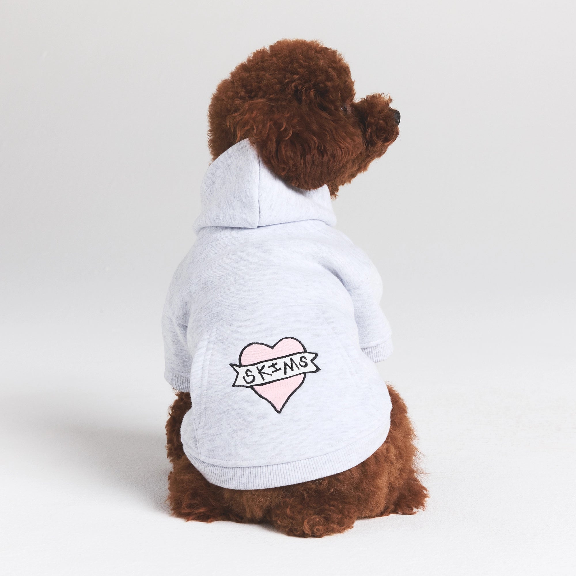 COTTON FLEECE PET HOODIE | LIGHT HEATHER GREY LOGO HEART ON A MODEL SIDE VIEW @ | FOCUS: 0.0, 1.0, 0.9