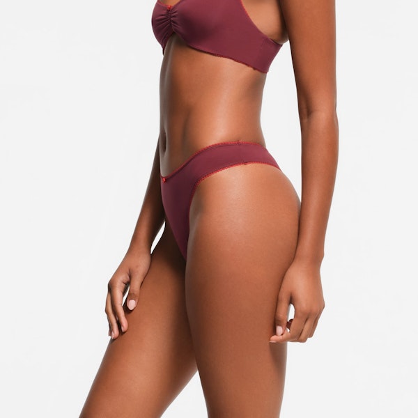 FITS EVERYBODY PICOT TRIM THONG | WINE CONTRAST ON A MODEL SIDE VIEW
