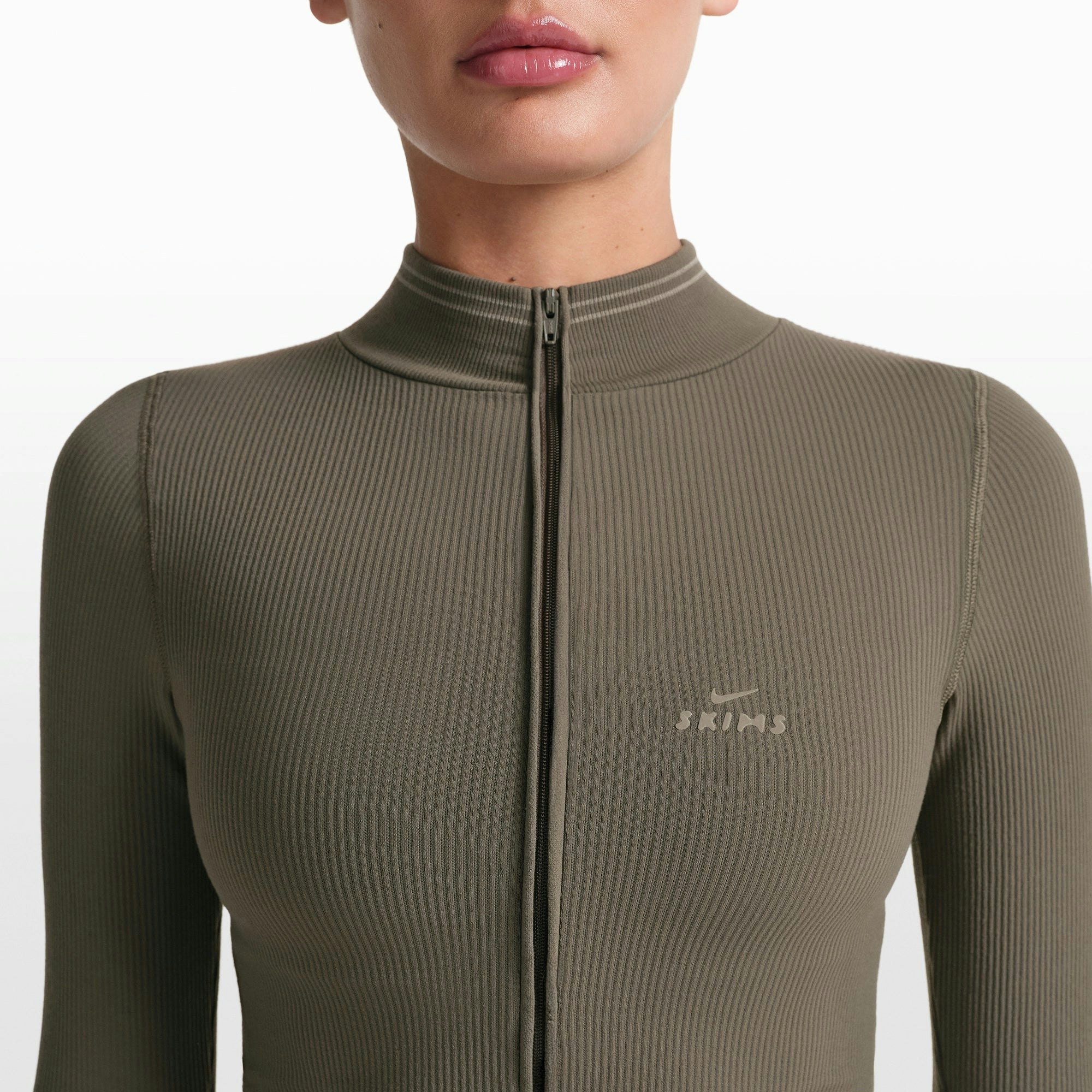 NikeSKIMS RIBBED SEAMLESS ZIP UP CROP JACKET | DUSTY OAKMOSS ON A MODEL FRONT VIEW @ | FOCUS: 0.0, 1.0, 0.9