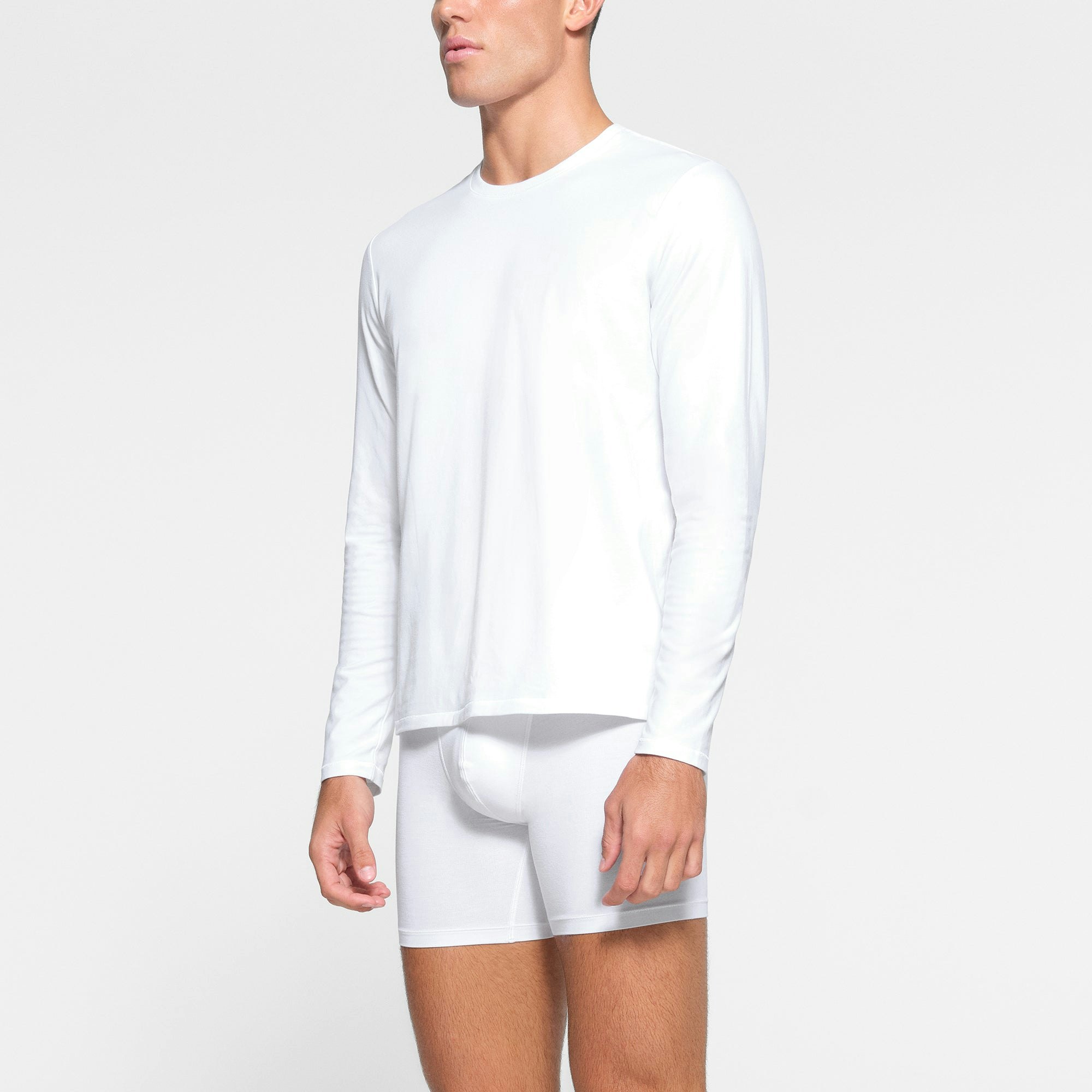 SKIMS COTTON MENS LONG SLEEVE T-SHIRT WORN BY A MODEL IN SIDE VIEW