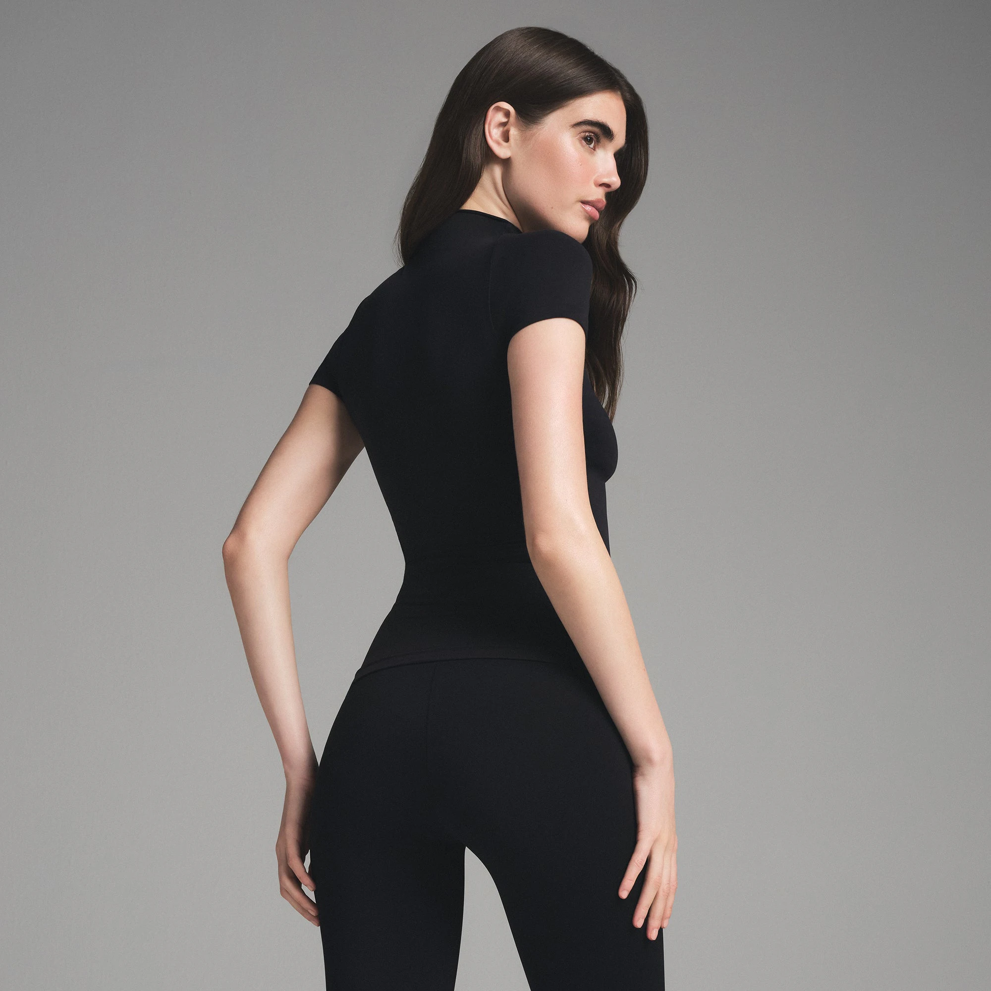 SEAMLESS SCULPT ZIP FRONT T-SHIRT | ONYX ON A MODEL SIDE VIEW | FOCUS: 0.0, 1.0, 0.9