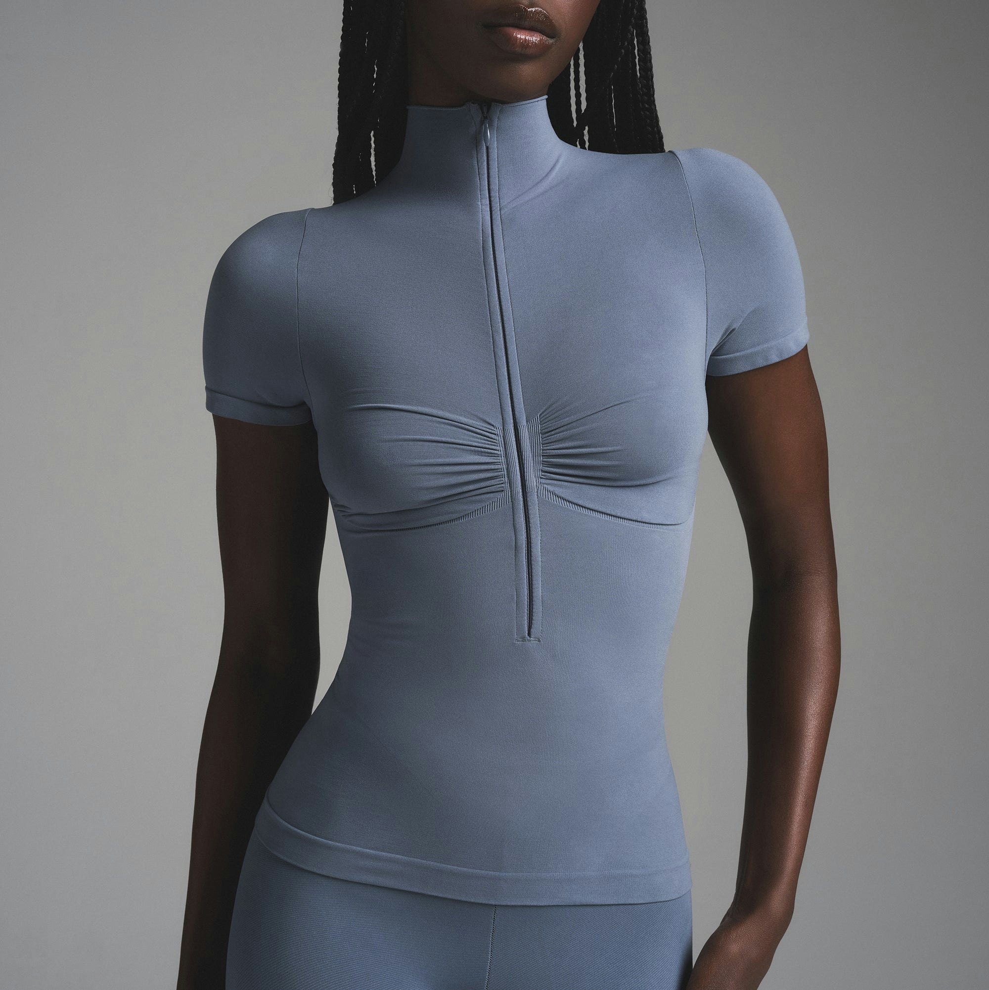 SEAMLESS SCULPT ZIP FRONT T-SHIRT | STEEL BLUE ON A MODEL SIDE VIEW | FOCUS: 0.0, 1.0, 0.9