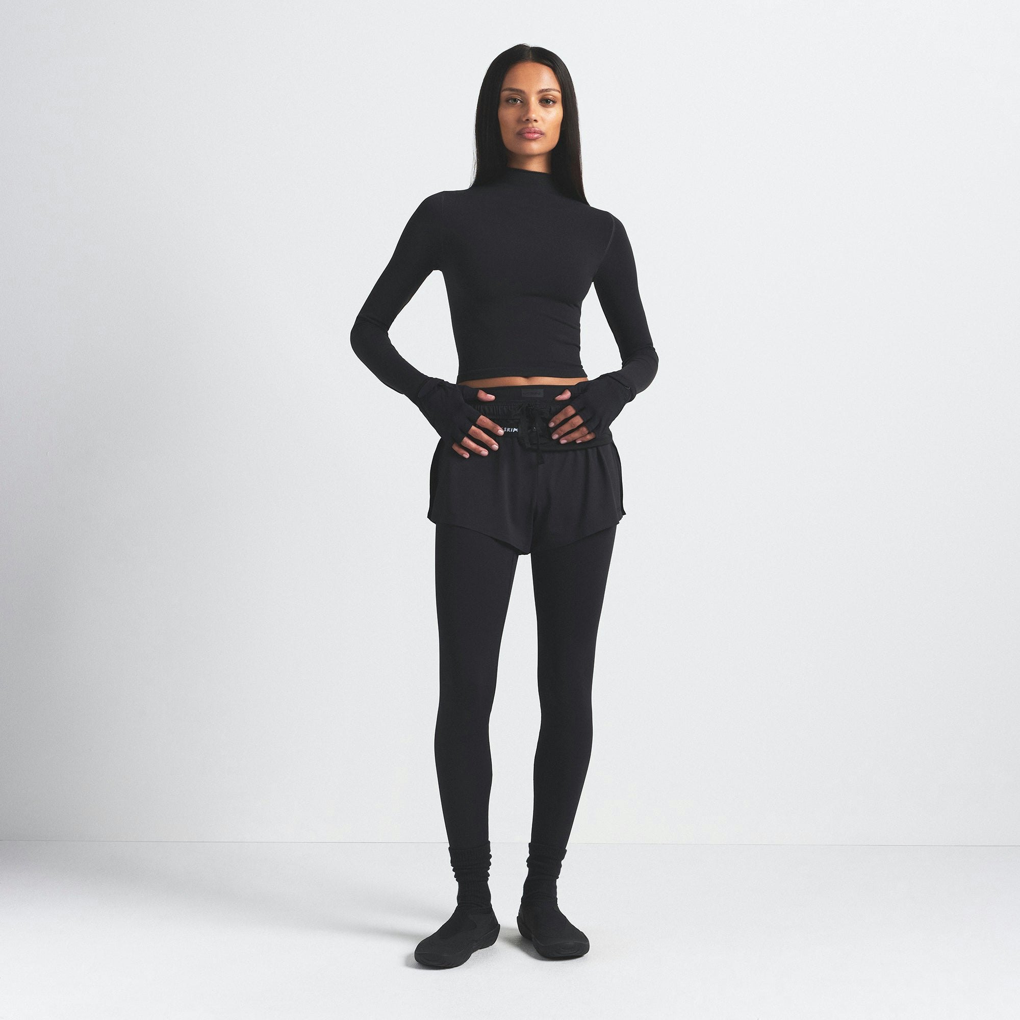NikeSKIMS VINTAGE SEAMLESS MOCK NECK CROP TOP | OBSIDIAN ON A MODEL FRONT VIEW @ | FOCUS: 0.9, 0.1, 0.7