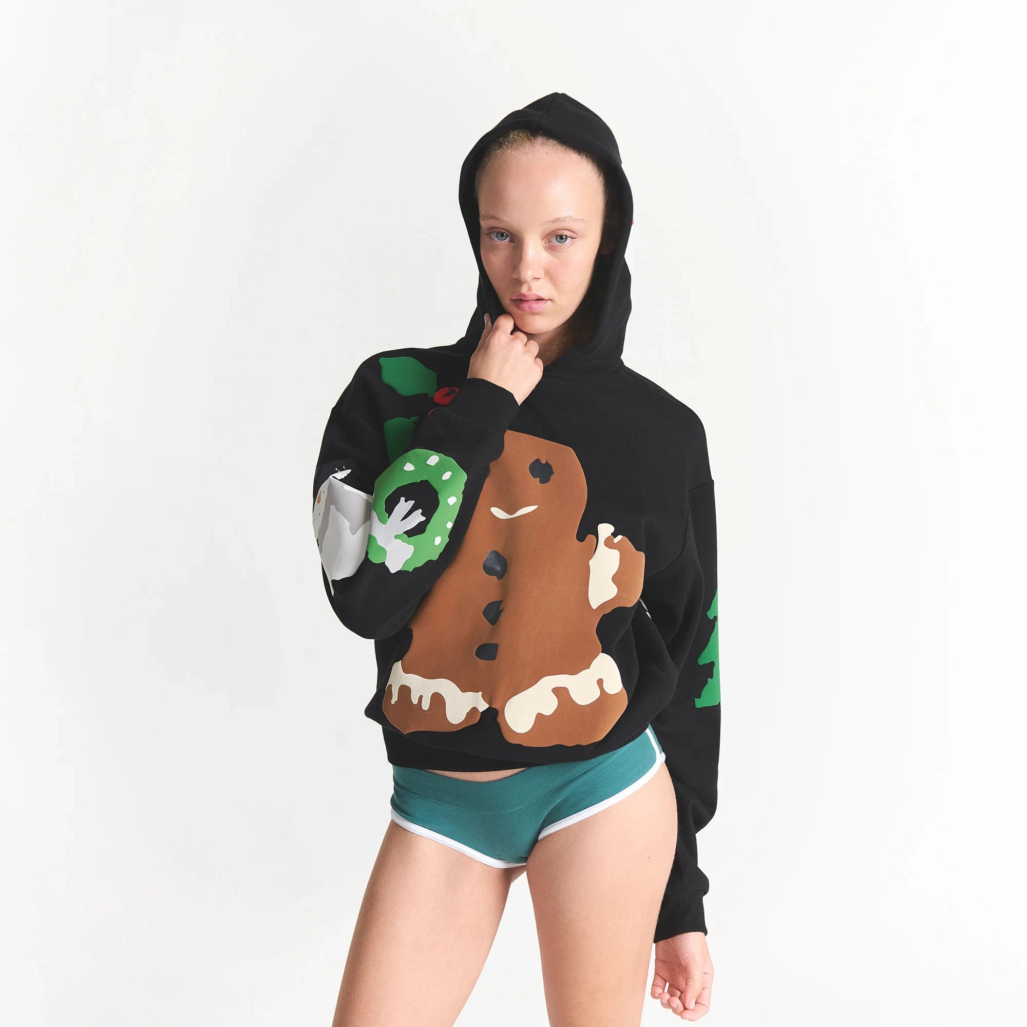 CACTUS PLANT FLEA MARKET X SKIMS COTTON FLEECE HOODIE | ONYX GINGERBREAD PRINT ON A MODEL FRONT VIEW @ | FOCUS: 0.0, 1.0, 0.9
