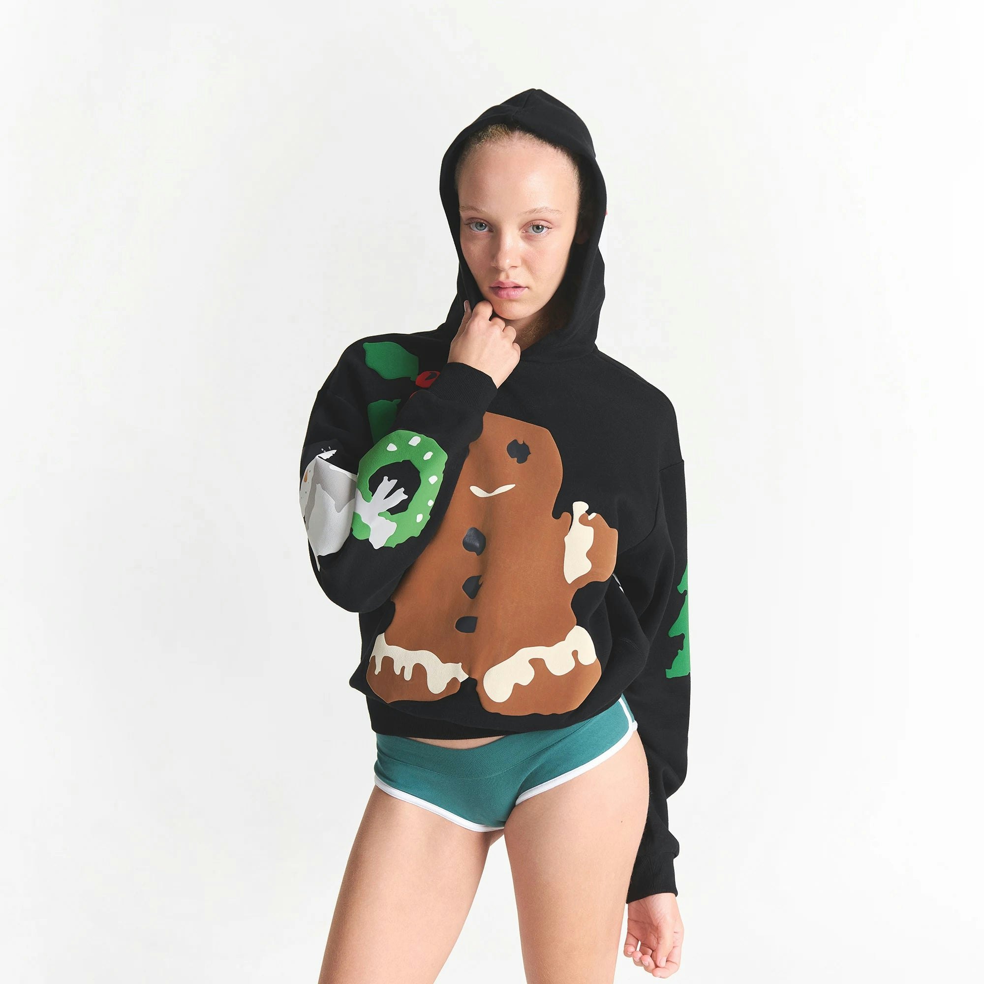 CACTUS PLANT FLEA MARKET X SKIMS COTTON FLEECE HOODIE | ONYX GINGERBREAD PRINT ON A MODEL FRONT VIEW @ | FOCUS: 0.0, 1.0, 0.9