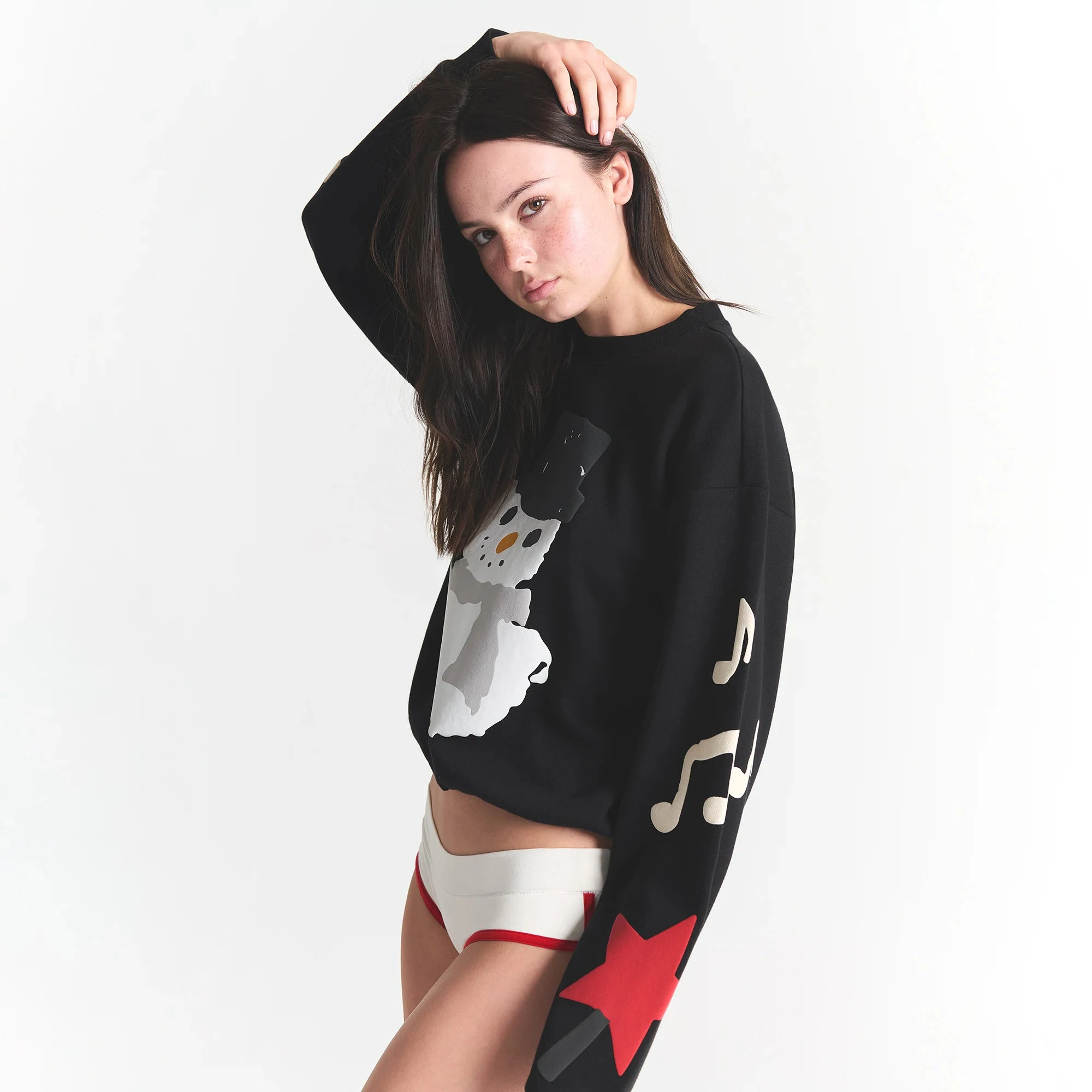 CACTUS PLANT FLEA MARKET X SKIMS COTTON FLEECE CREWNECK | ONYX SNOWMAN PRINT ON A MODEL SIDE VIEW @ | FOCUS: 0.0, 1.0, 0.9