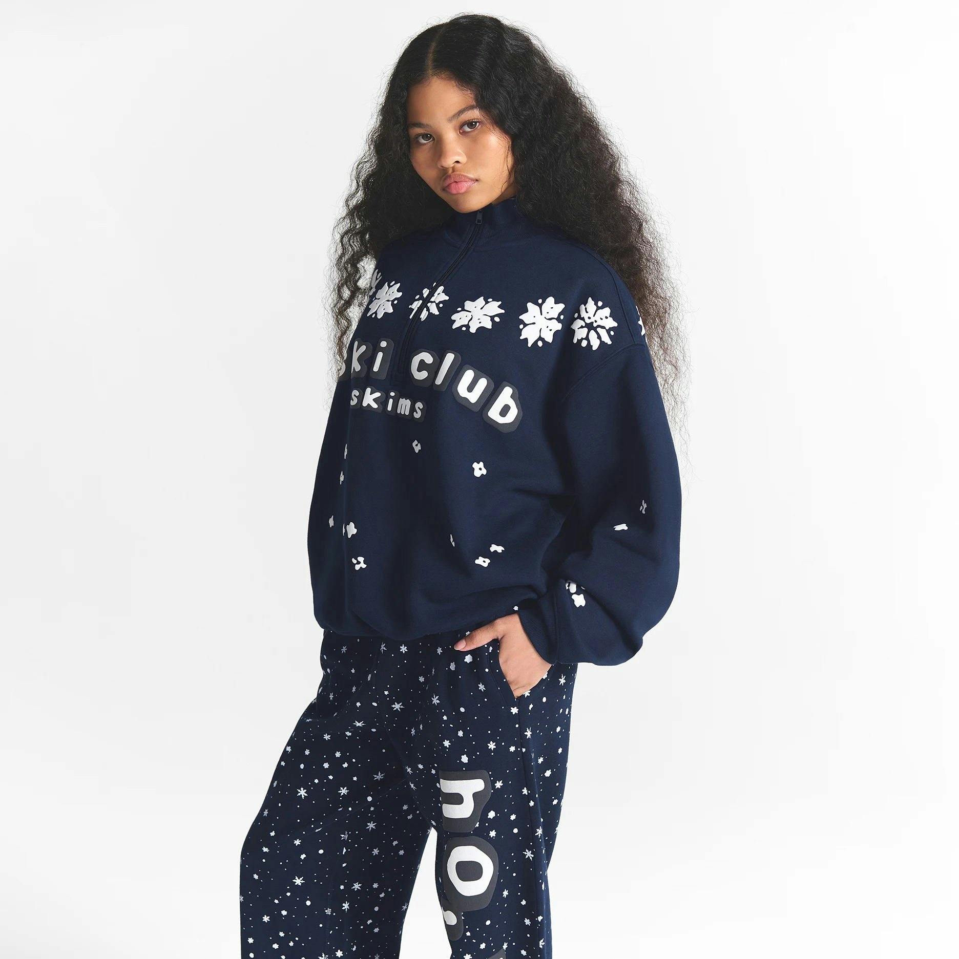 CACTUS PLANT FLEA MARKET X SKIMS COTTON FLEECE OVERSIZED QUARTER ZIP | NAVY SKI CLUB PRINT ON A MODEL SIDE VIEW @ | FOCUS: 0.0, 1.0, 0.9