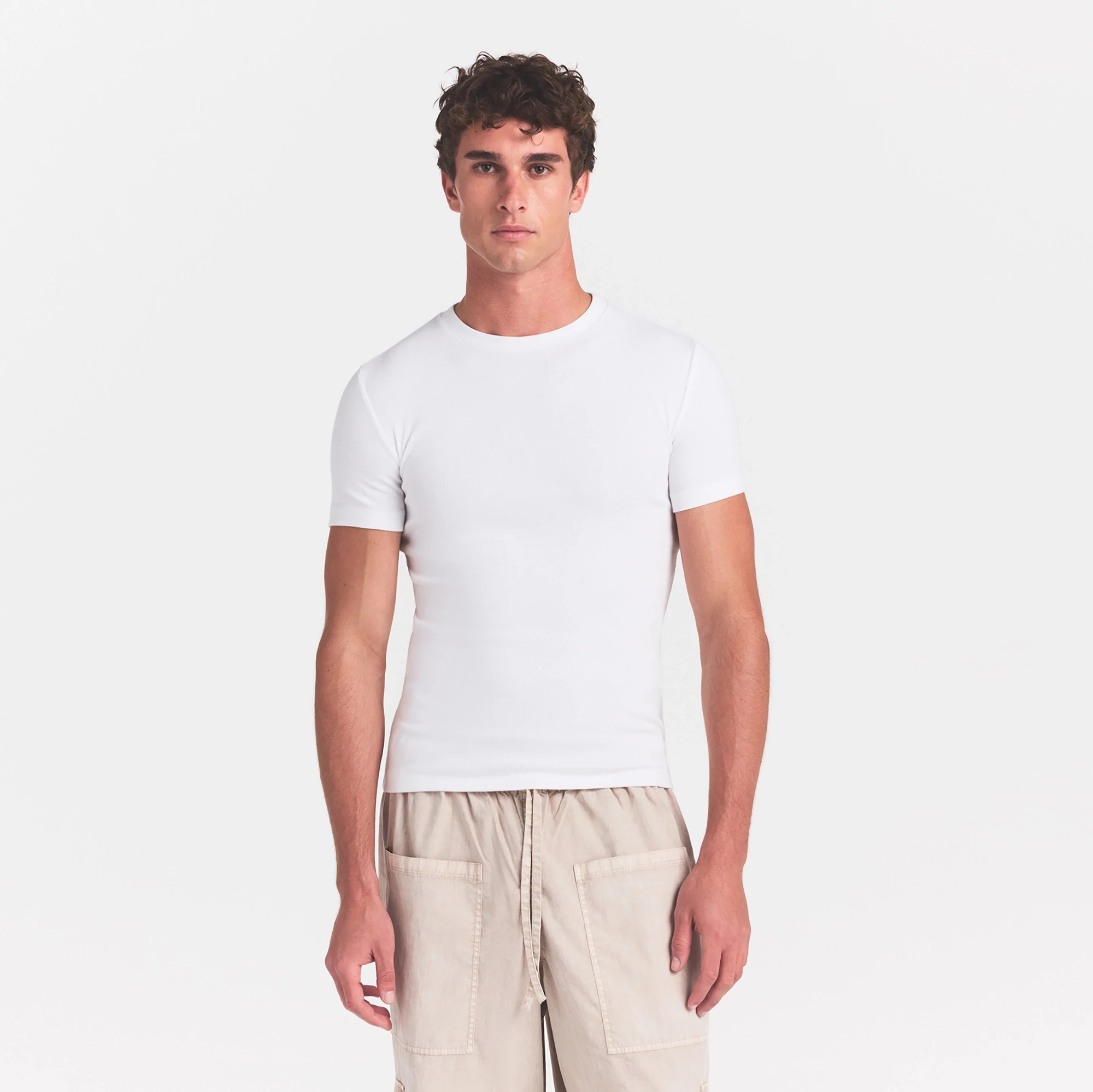 SKIMS COTTON RIB MENS T-SHIRT | CHALK ON A MODEL SIDE VIEW @ | FOCUS: 0.0, 1.0, 0.9