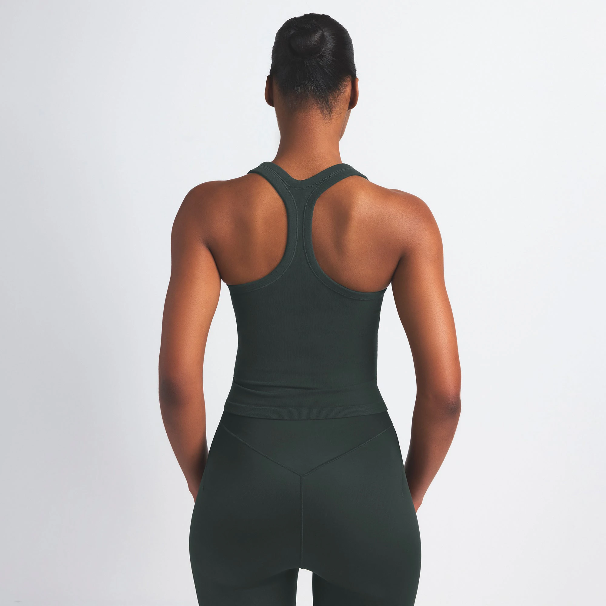 NikeSKIMS VINTAGE SEAMLESS RACER BACK TANK | DARK TEAL ON A MODEL SIDE VIEW @ | FOCUS: 0.0, 1.0, 0.9