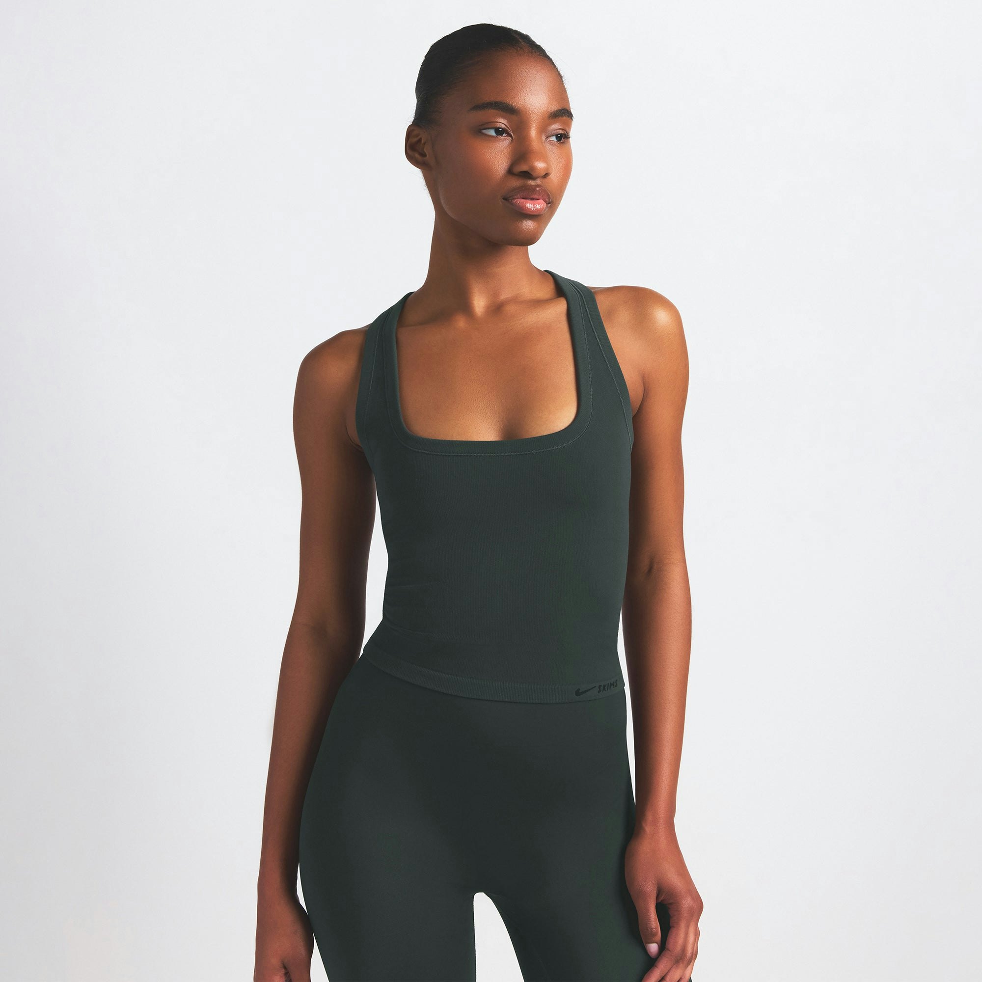 NikeSKIMS VINTAGE SEAMLESS RACER BACK TANK | DARK TEAL ON A MODEL SIDE VIEW @ | FOCUS: 0.0, 1.0, 0.9