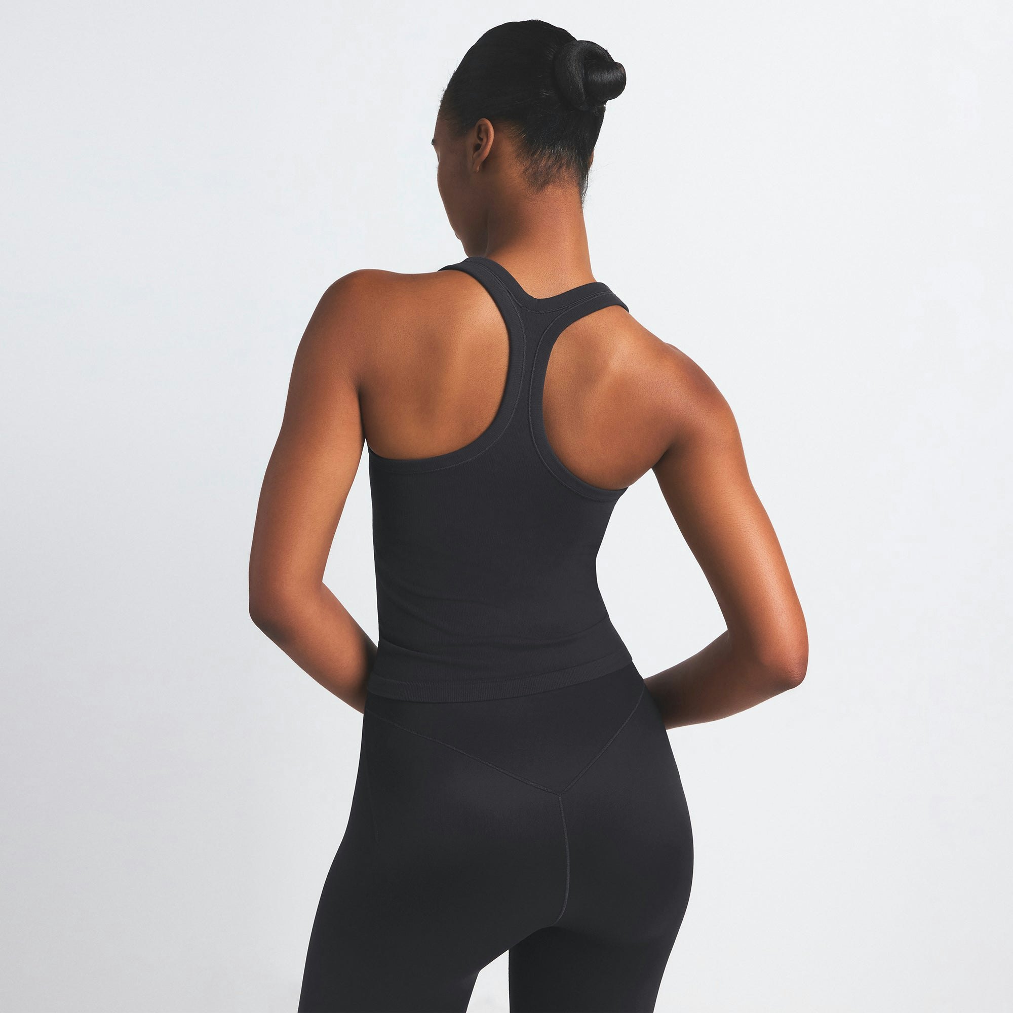 NikeSKIMS VINTAGE SEAMLESS RACER BACK TANK | OBSIDIAN ON A MODEL SIDE VIEW @ | FOCUS: 0.9, 0.1, 0.7