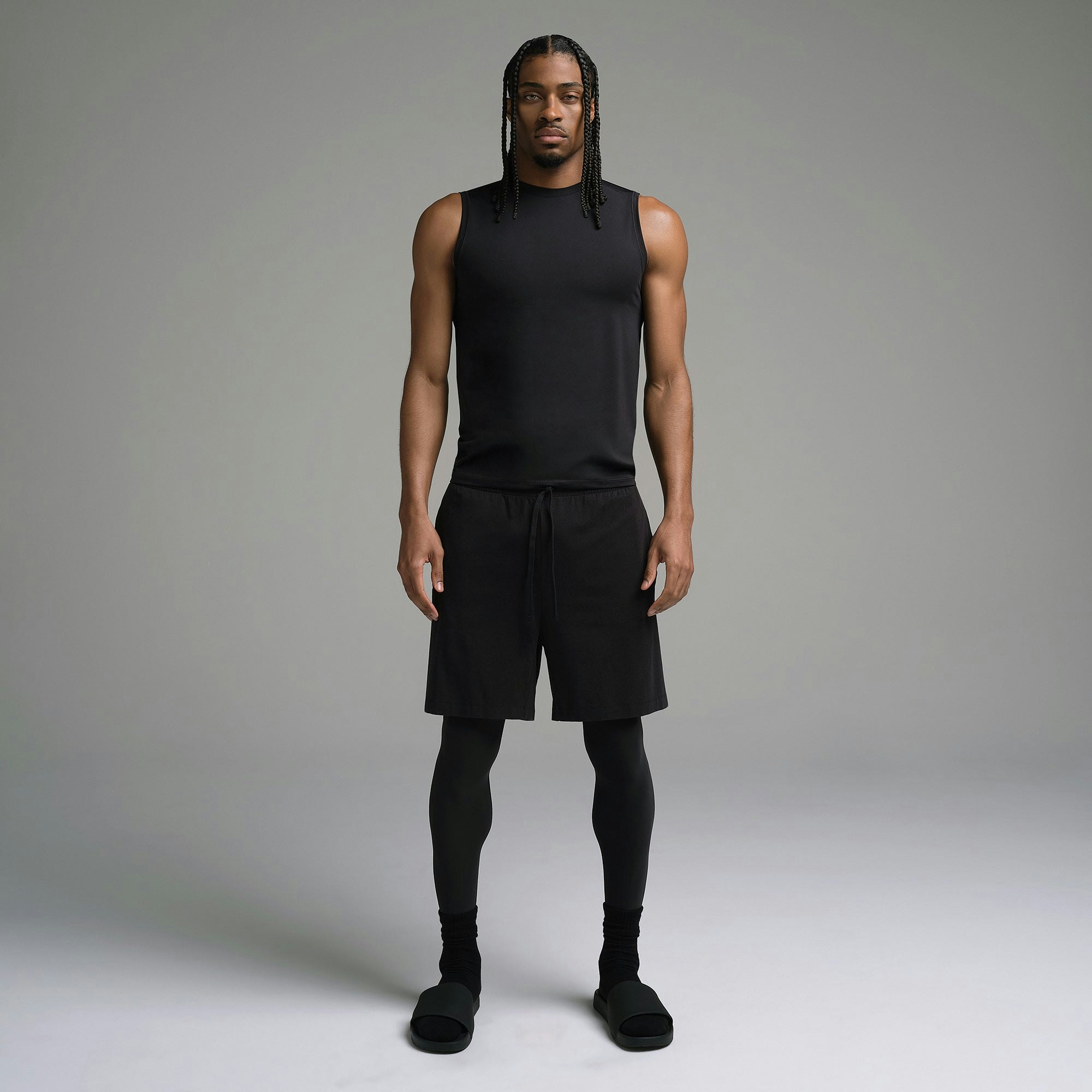 SKIMS SPORT MENS MUSCLE TANK | OBSIDIAN ON A MODEL FRONT VIEW | FOCUS: 0.0, 1.0, 0.9