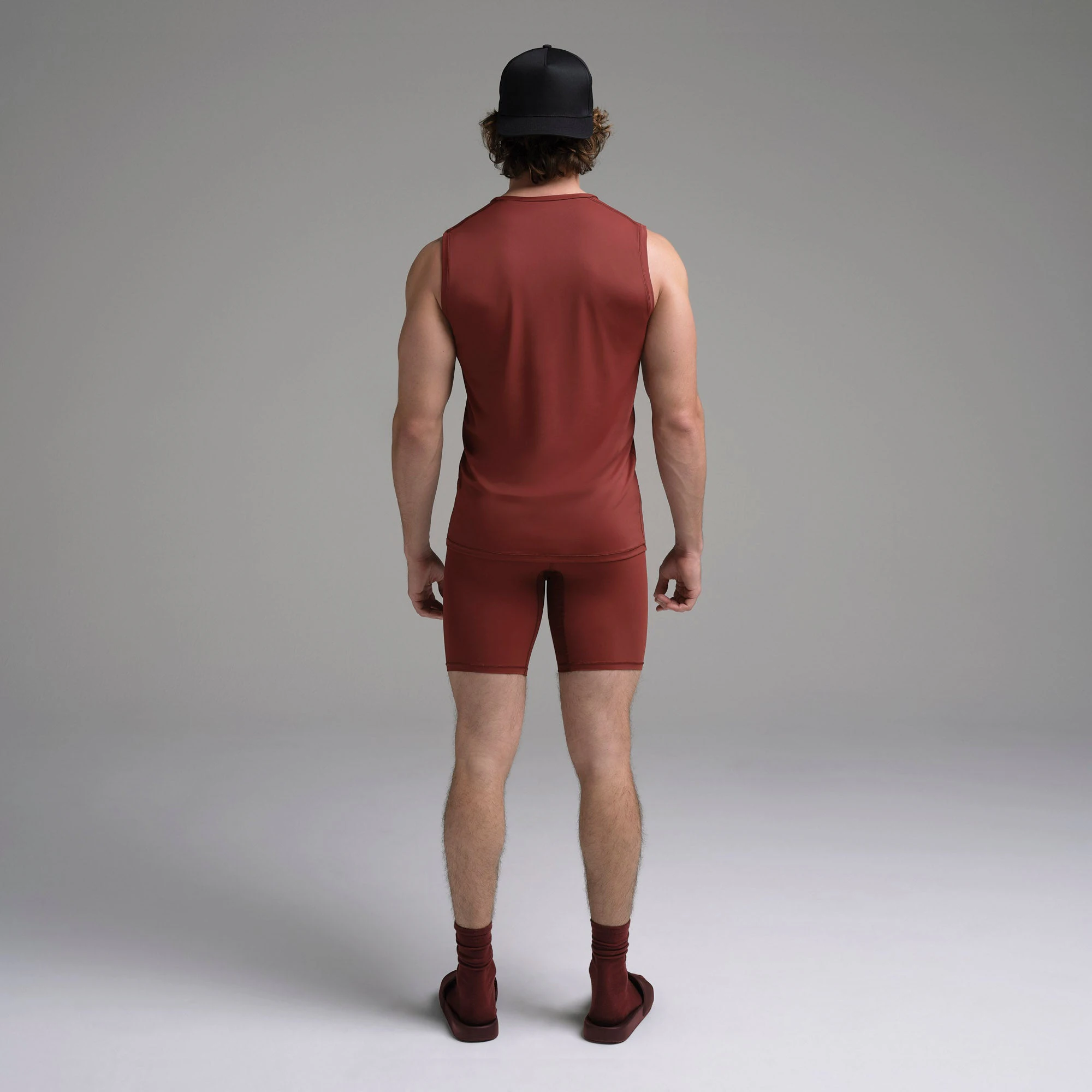 SKIMS SPORT MENS MUSCLE TANK | SANGRIA ON A MODEL SIDE VIEW | FOCUS: 0.0, 1.0, 0.9