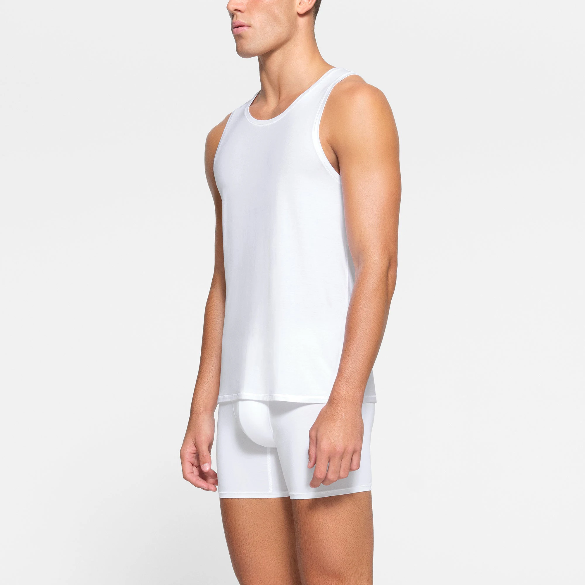 SKIMS STRETCH MENS TANK 3-PACK WORN BY A MODEL IN SIDE VIEW