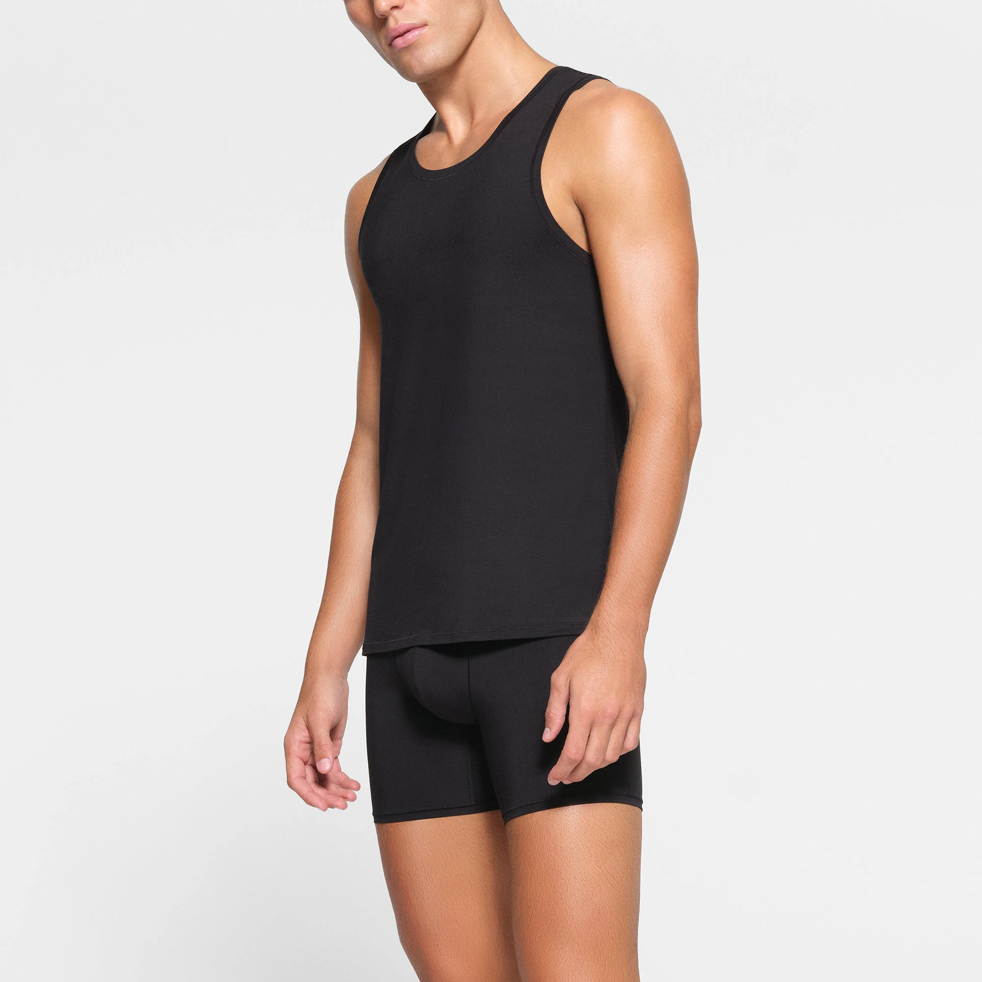 SKIMS STRETCH MENS TANK 3-PACK WORN BY A MODEL IN SIDE VIEW