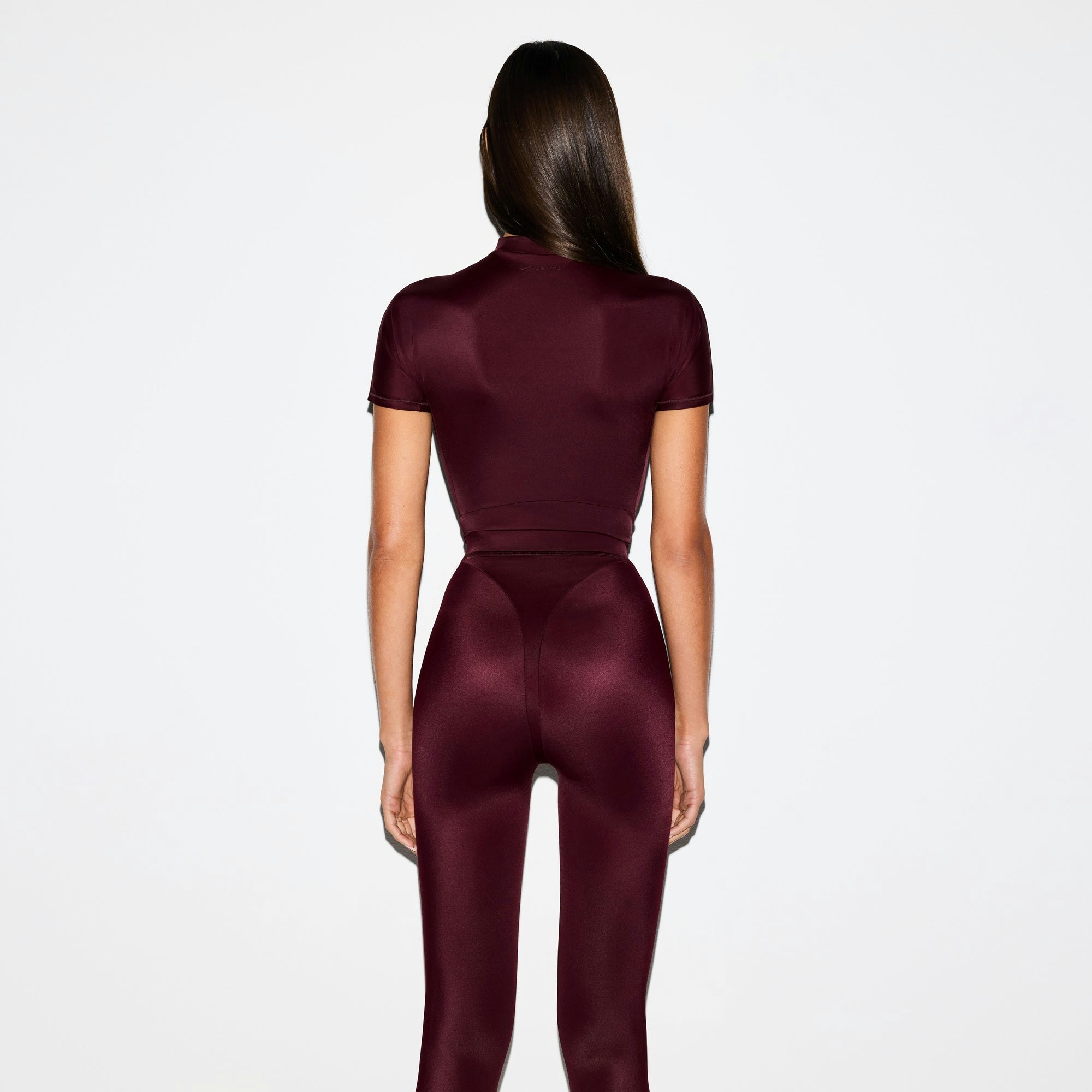 NikeSKIMS SHINE SHORT SLEEVE MOCK NECK TOP | CURRANT ON A MODEL SIDE VIEW @ | FOCUS: 0.0, 1.0, 0.9